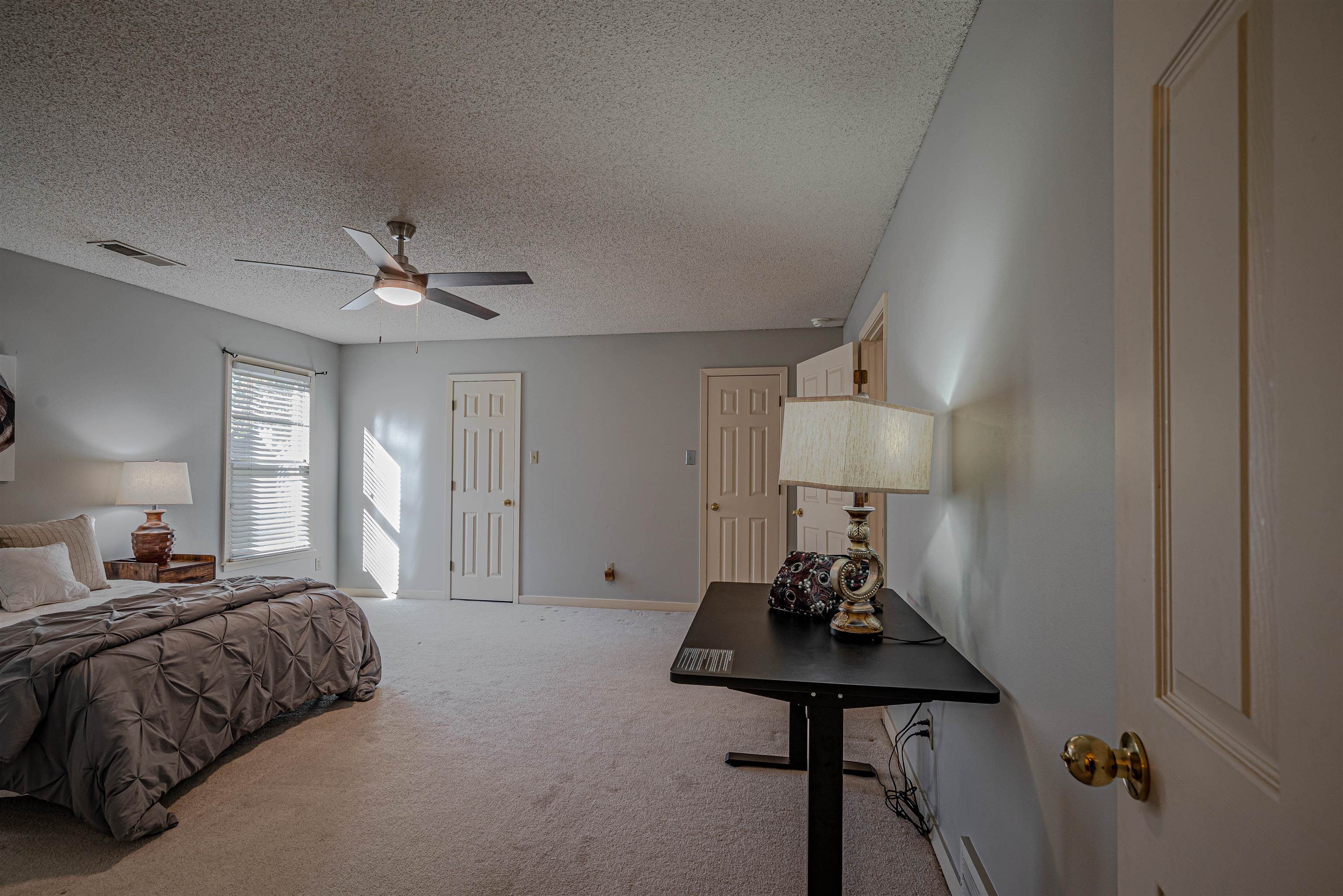 Bedroom with carpet, a textured ceiling, and ceiling fan