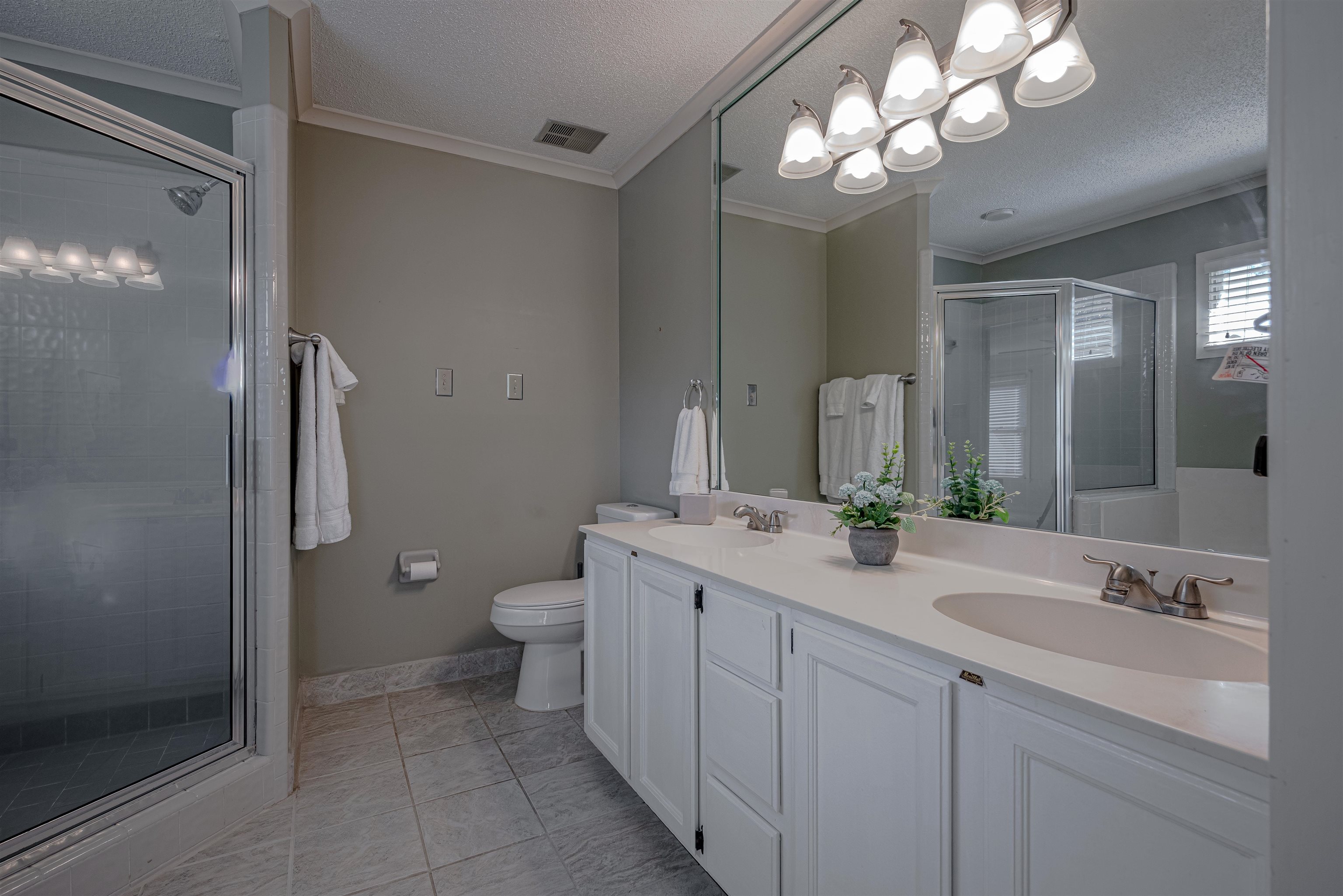 Bathroom featuring walk in shower, crown molding, a textured ceiling, toilet, and vanity