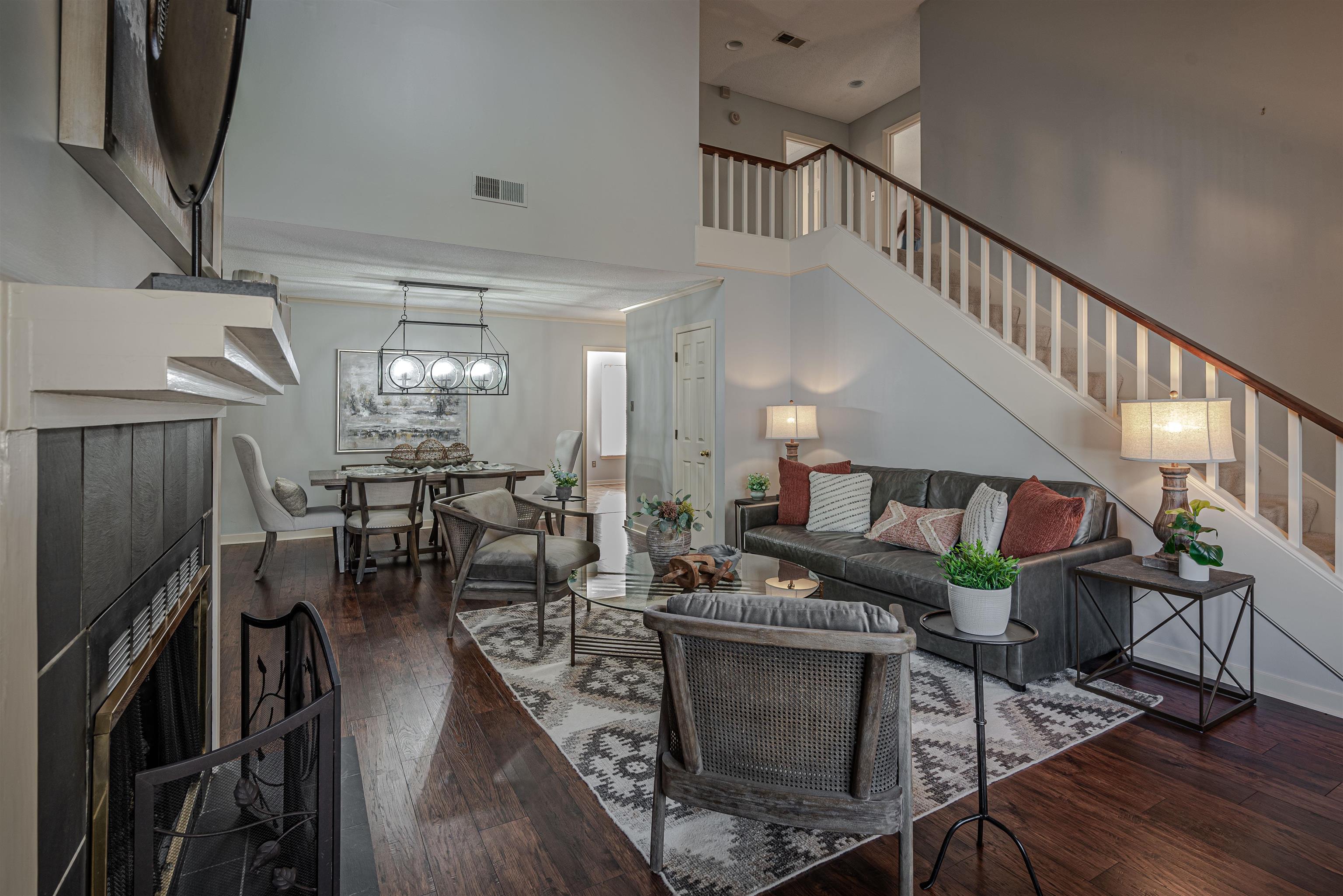 Living room featuring a high ceiling, dark hardwood / wood-style flooring, and a tiled fireplace