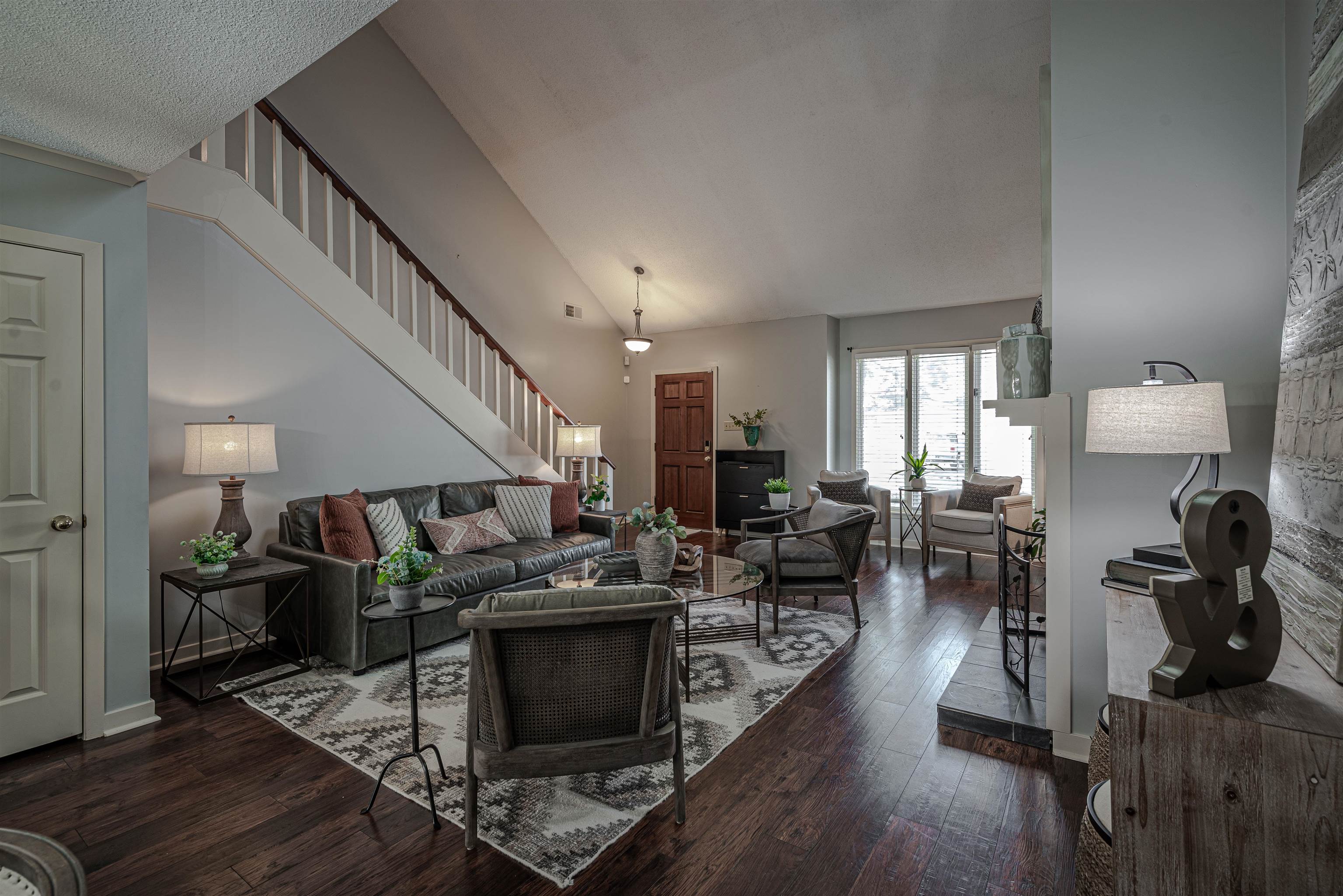 Living room featuring dark hardwood / wood-style floors and high vaulted ceiling