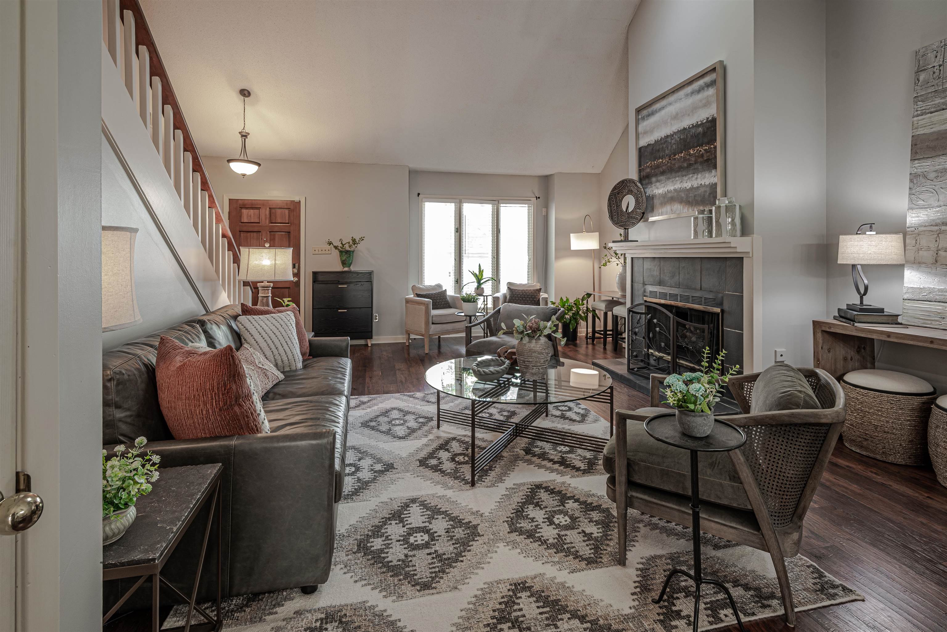 Living room featuring a tiled fireplace, lofted ceiling, and dark hardwood / wood-style floors
