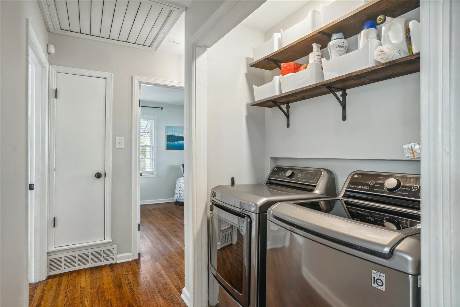 Laundry room featuring washer and dryer and dark wood-type flooring