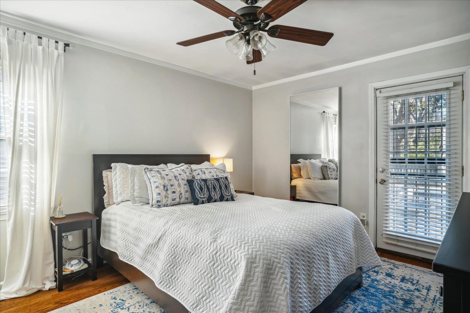 Bedroom with hardwood / wood-style floors, ceiling fan, and crown molding