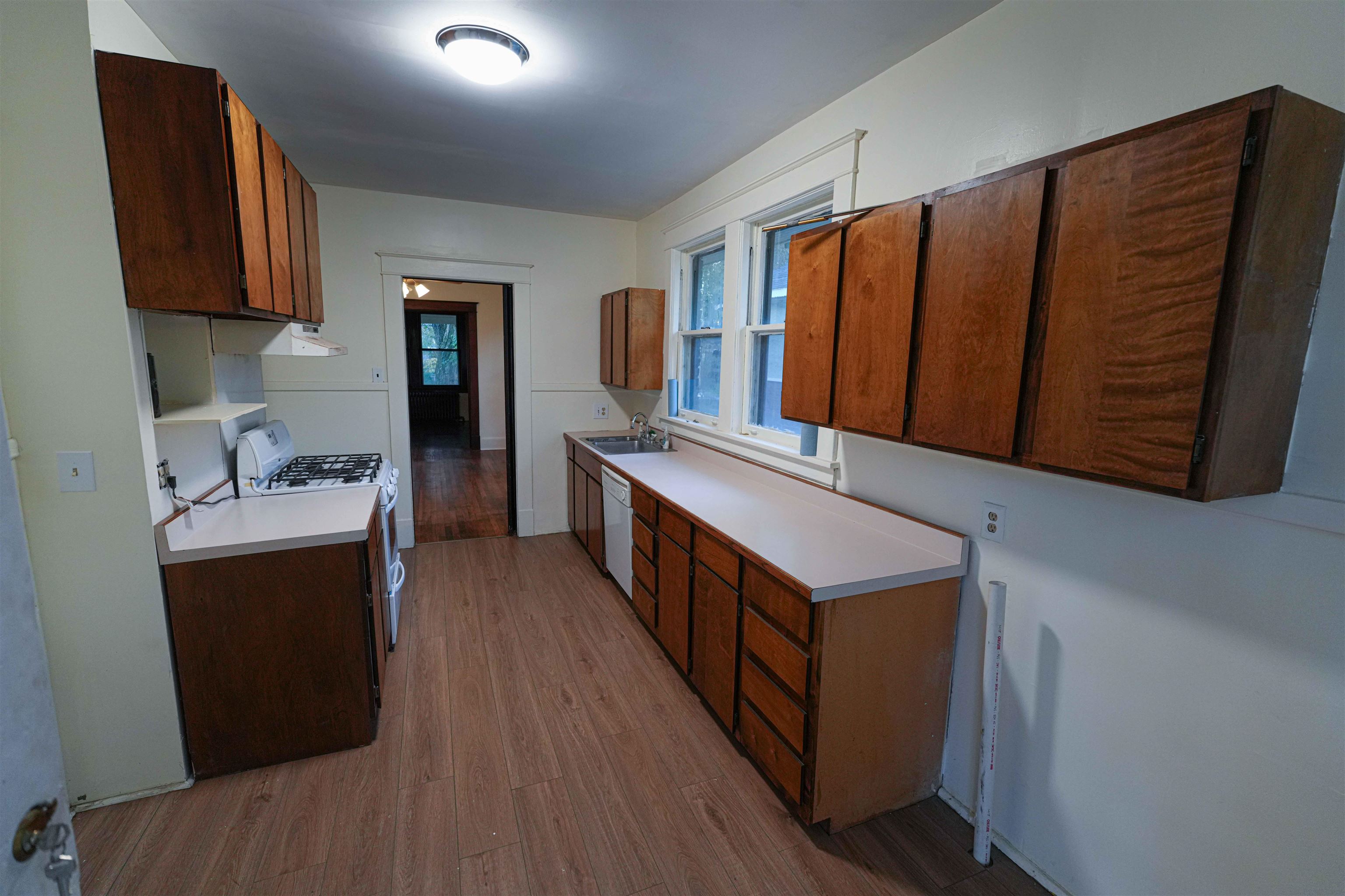 Kitchen featuring light wood-type flooring, white appliances, and sink