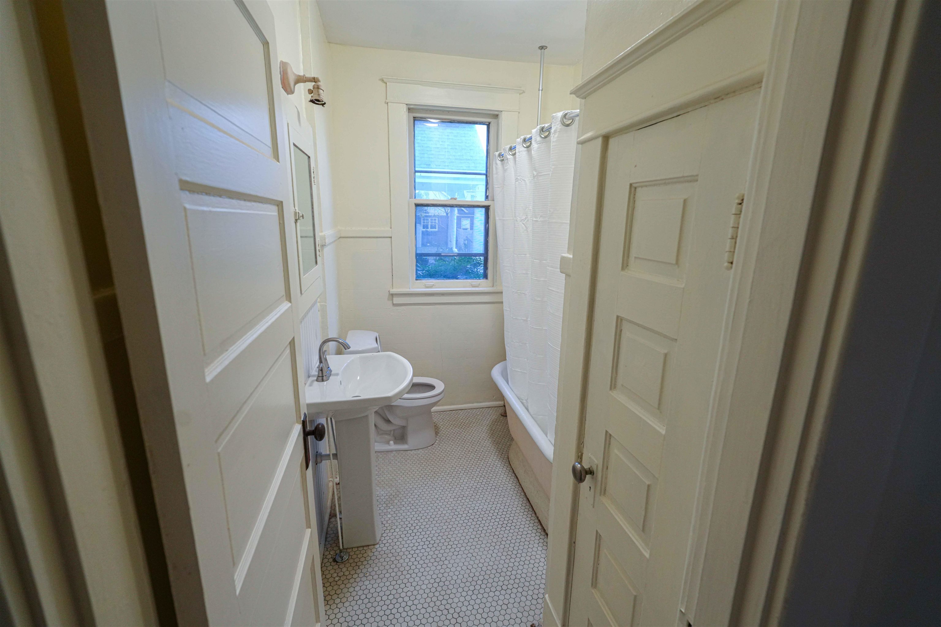 Bathroom featuring tile patterned floors, toilet, and shower / tub combo