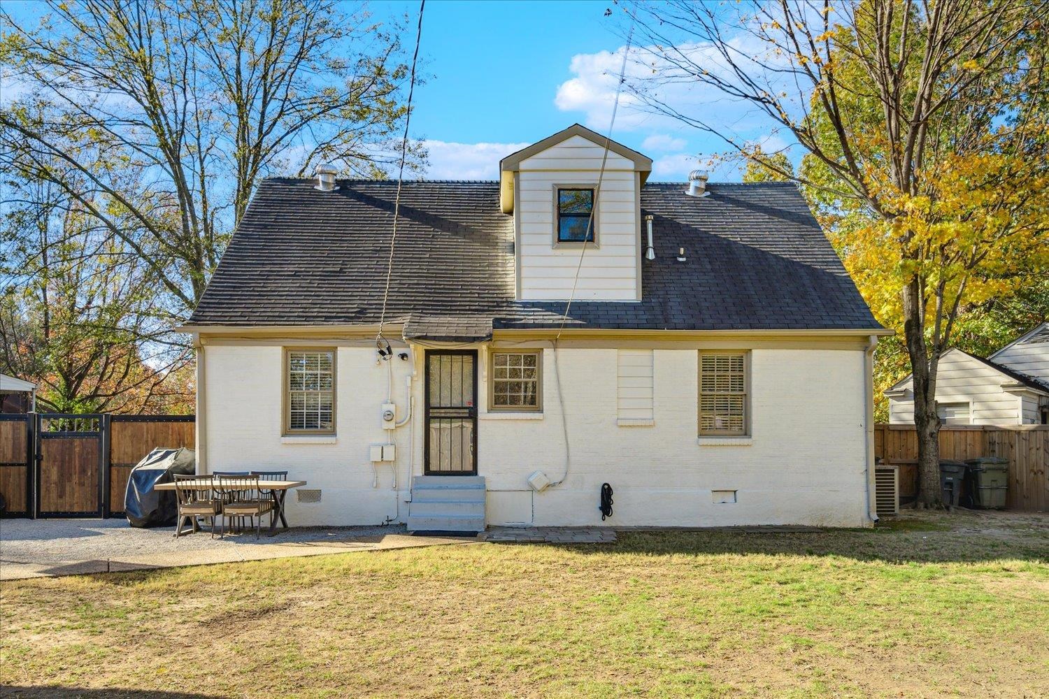 Back of property featuring a patio area and a lawn