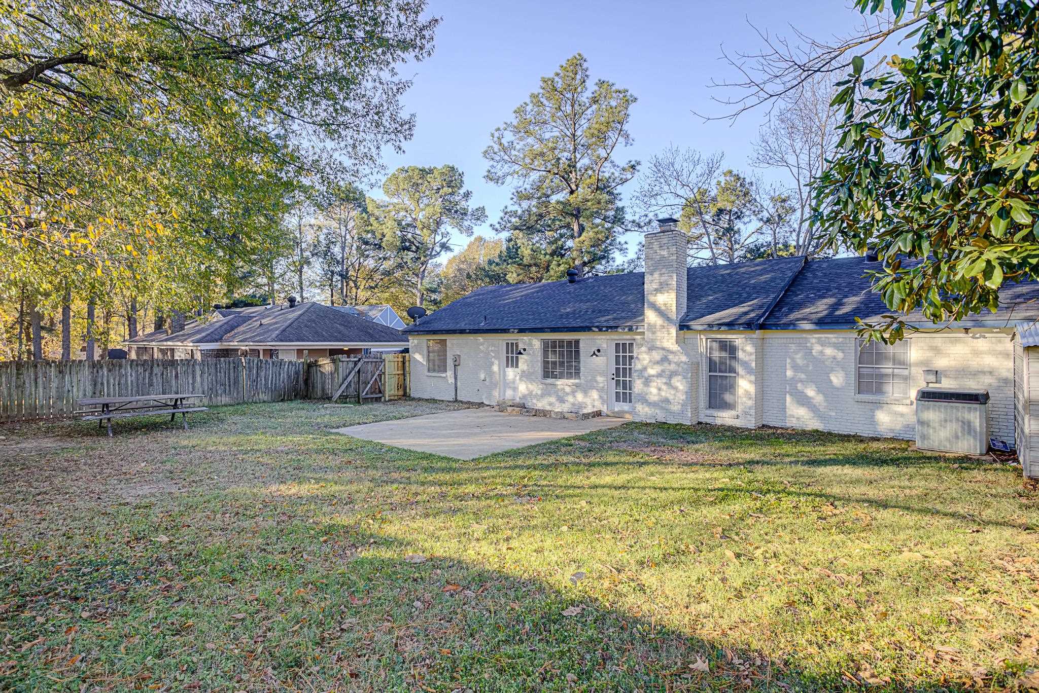 Rear view of property with a yard and a patio