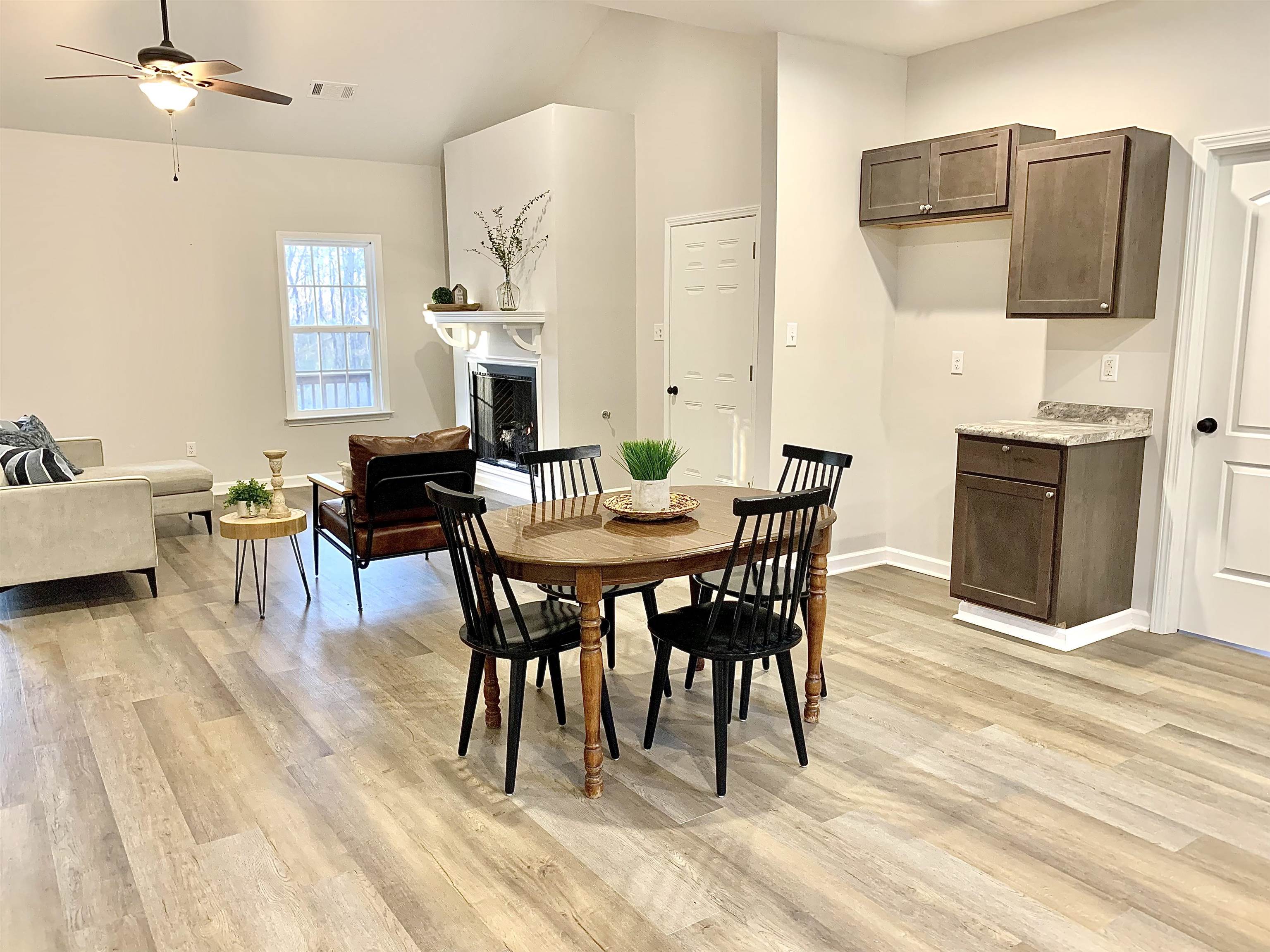 Dining room with ceiling fan, light wood-type flooring, and lofted ceiling