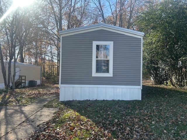 View of property exterior with a yard