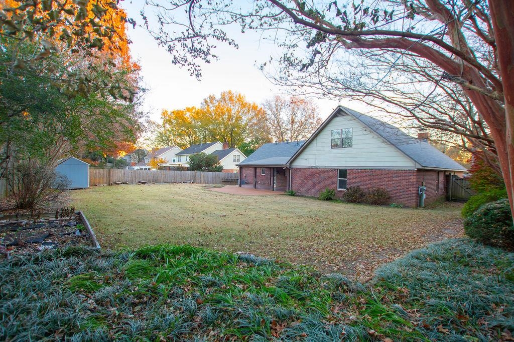 View of yard featuring a patio and a storage unit