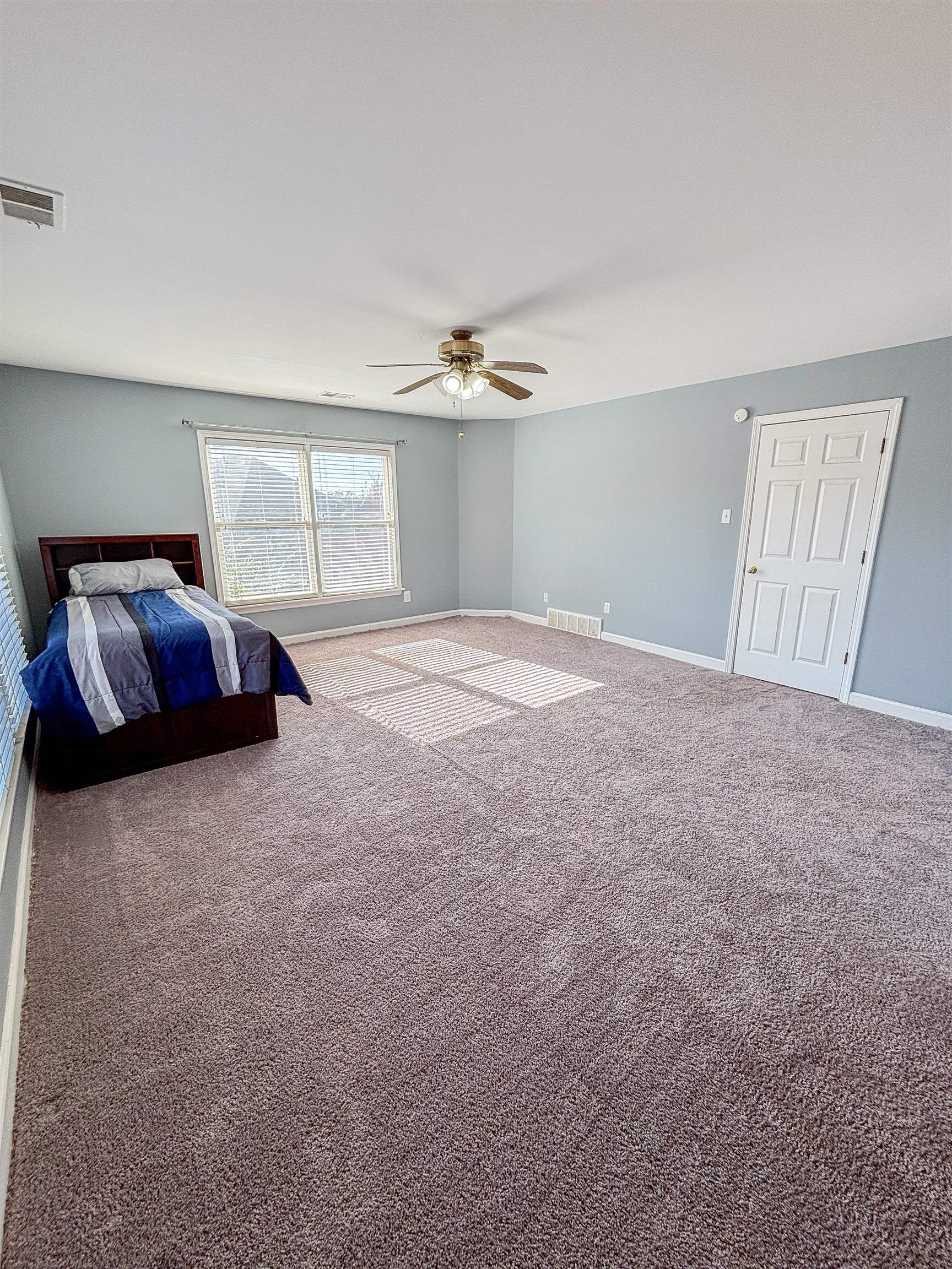 Unfurnished bedroom with carpet and ceiling fan