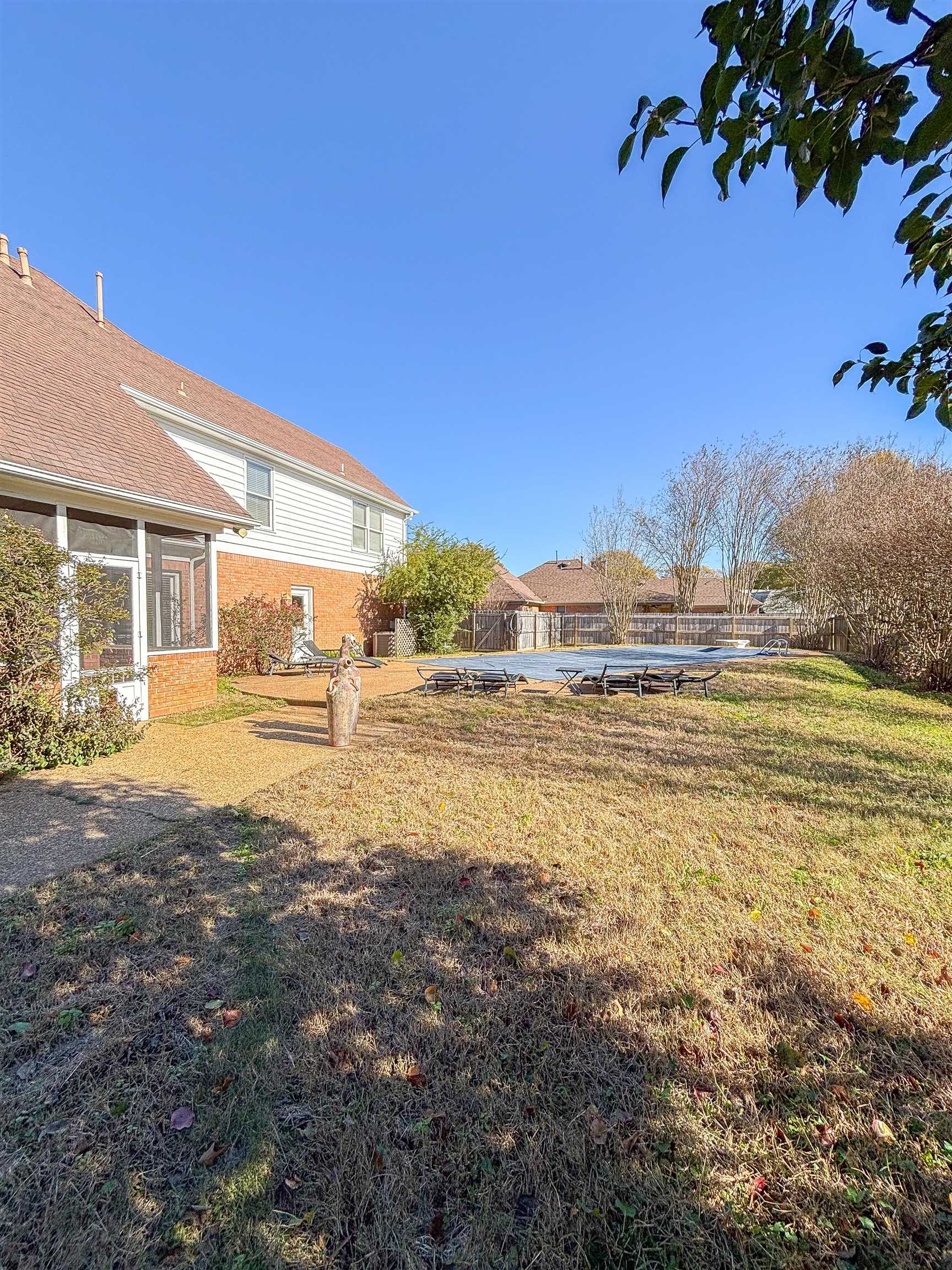 View of yard with a sunroom and a pool