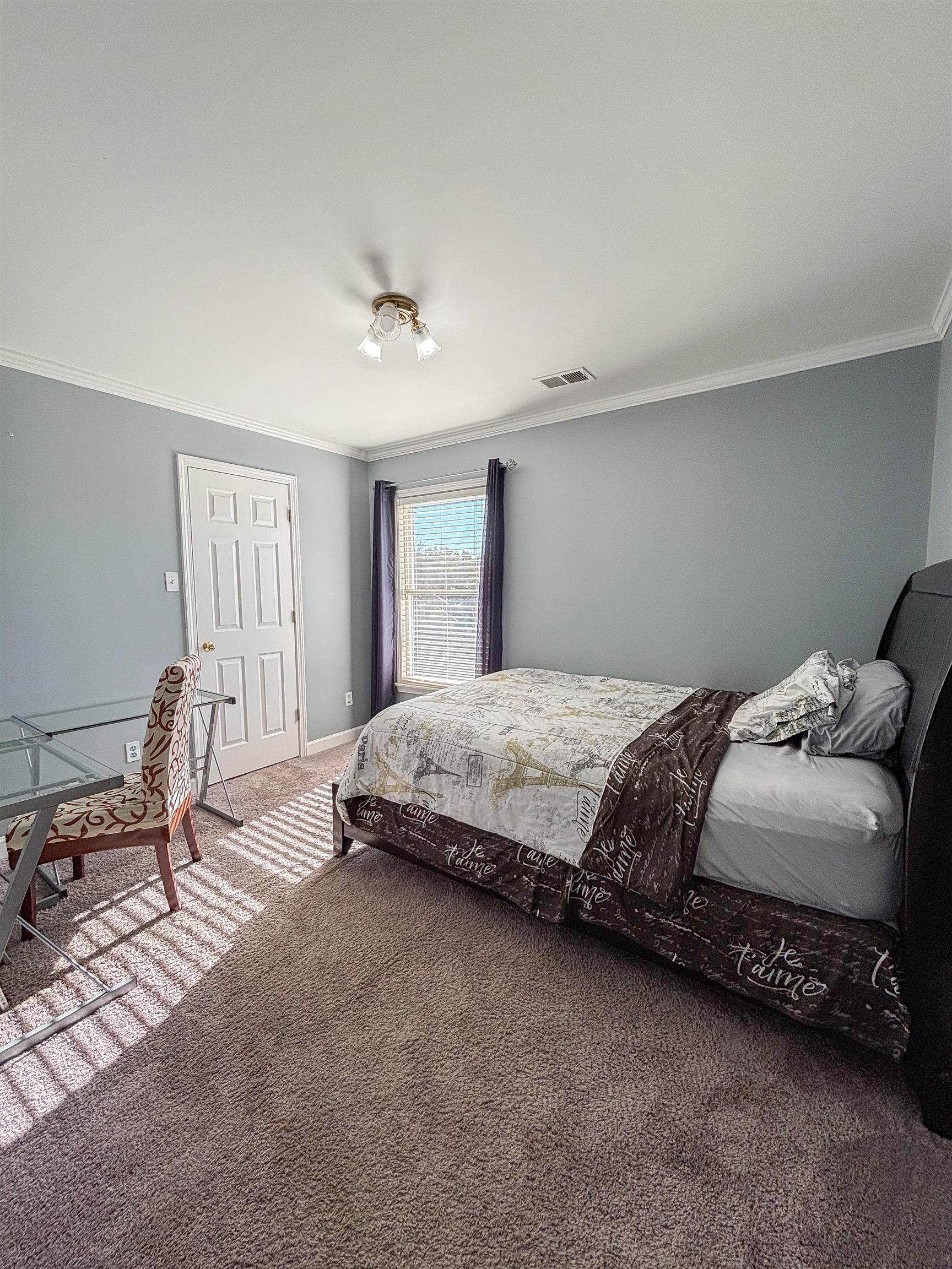 Carpeted bedroom with crown molding