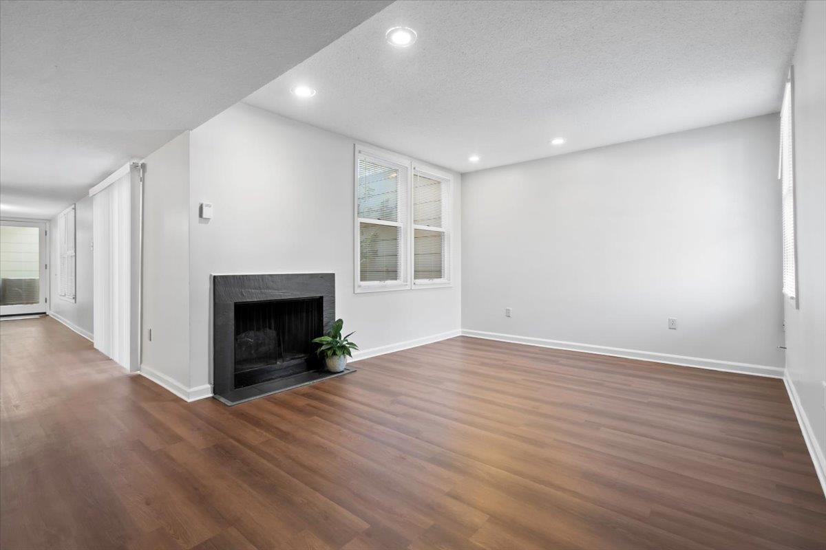 Unfurnished living room with dark hardwood / wood-style flooring and a textured ceiling