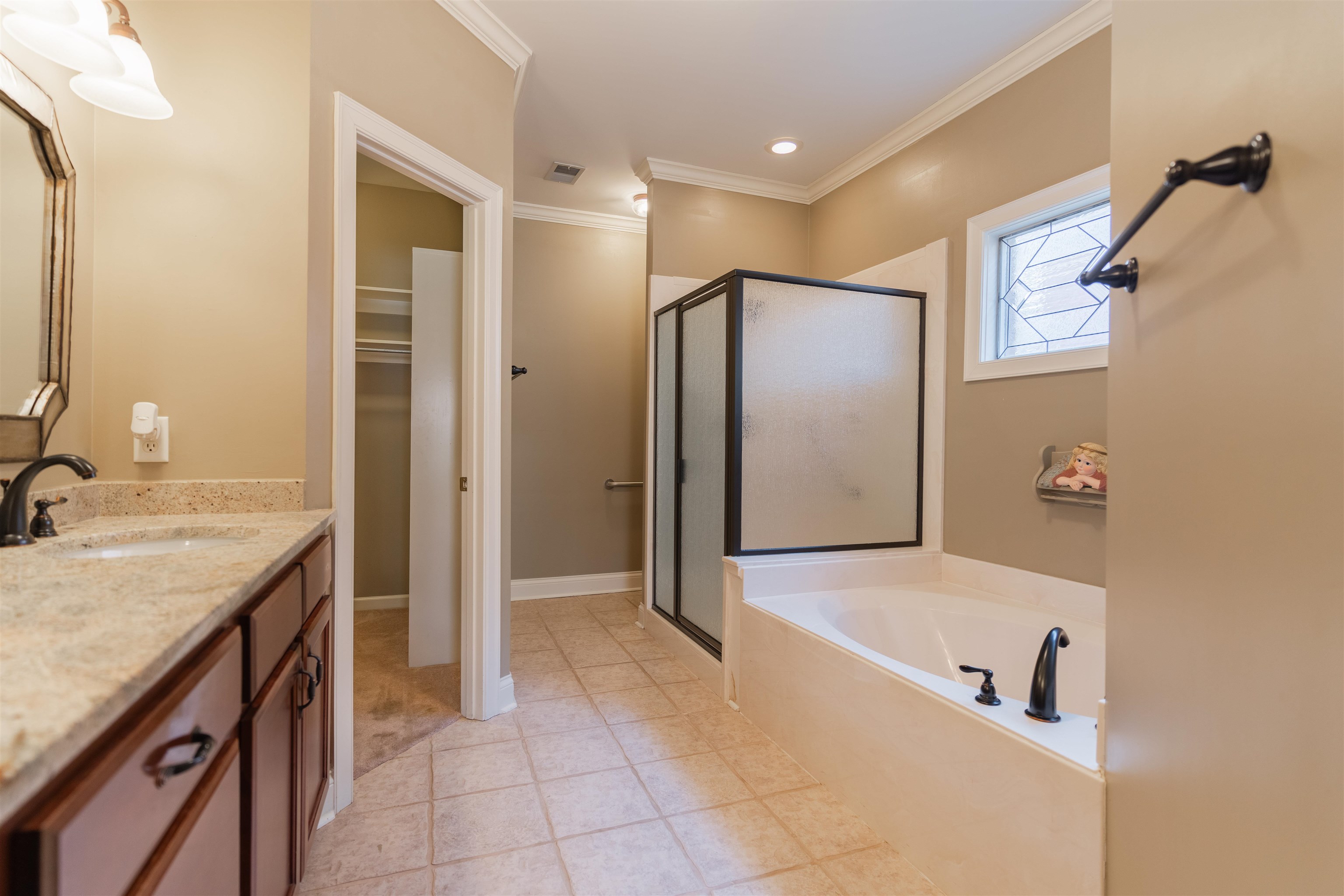 Bathroom with tile patterned floors, vanity, separate shower and tub, and crown molding