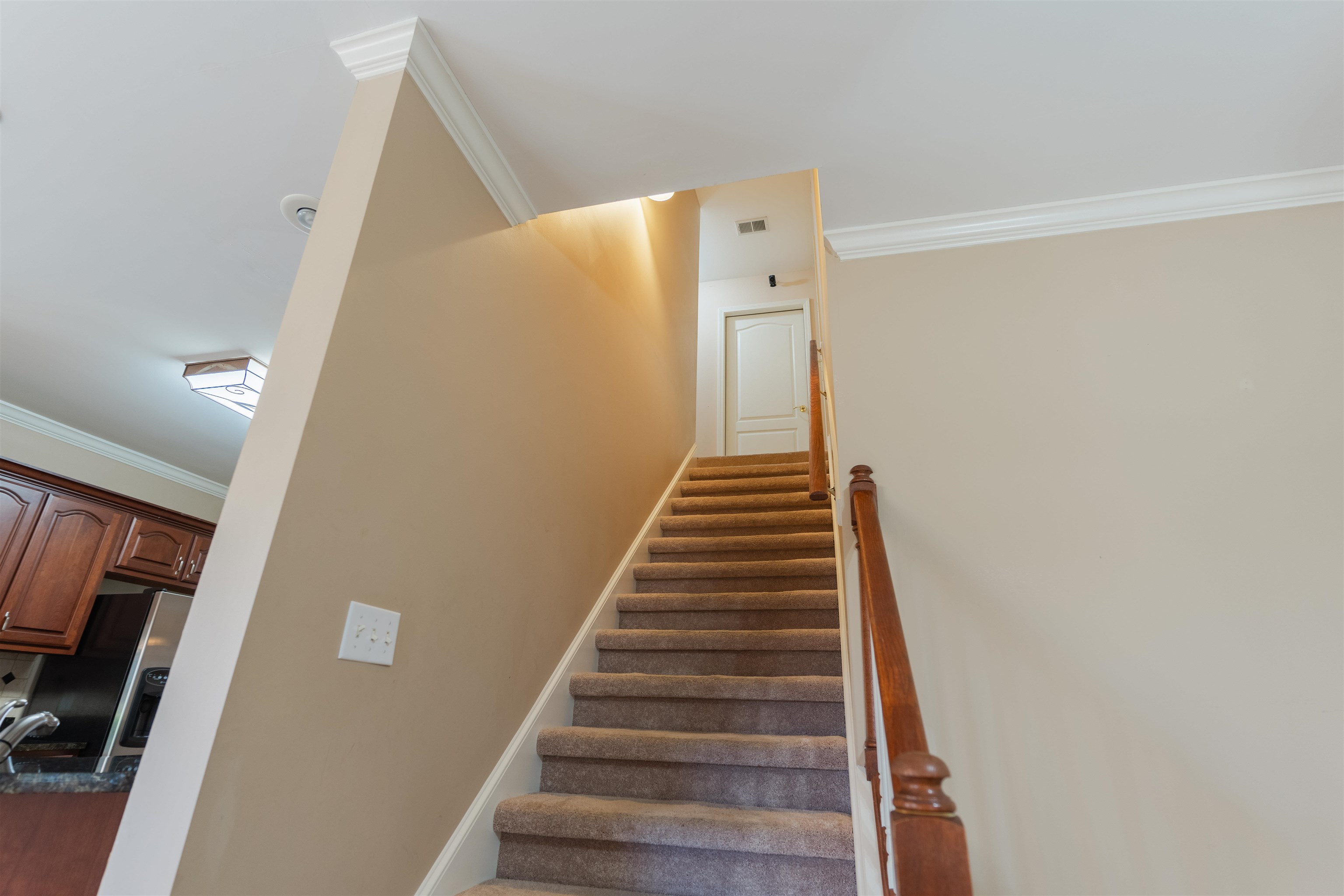 Staircase with crown molding and hardwood / wood-style flooring