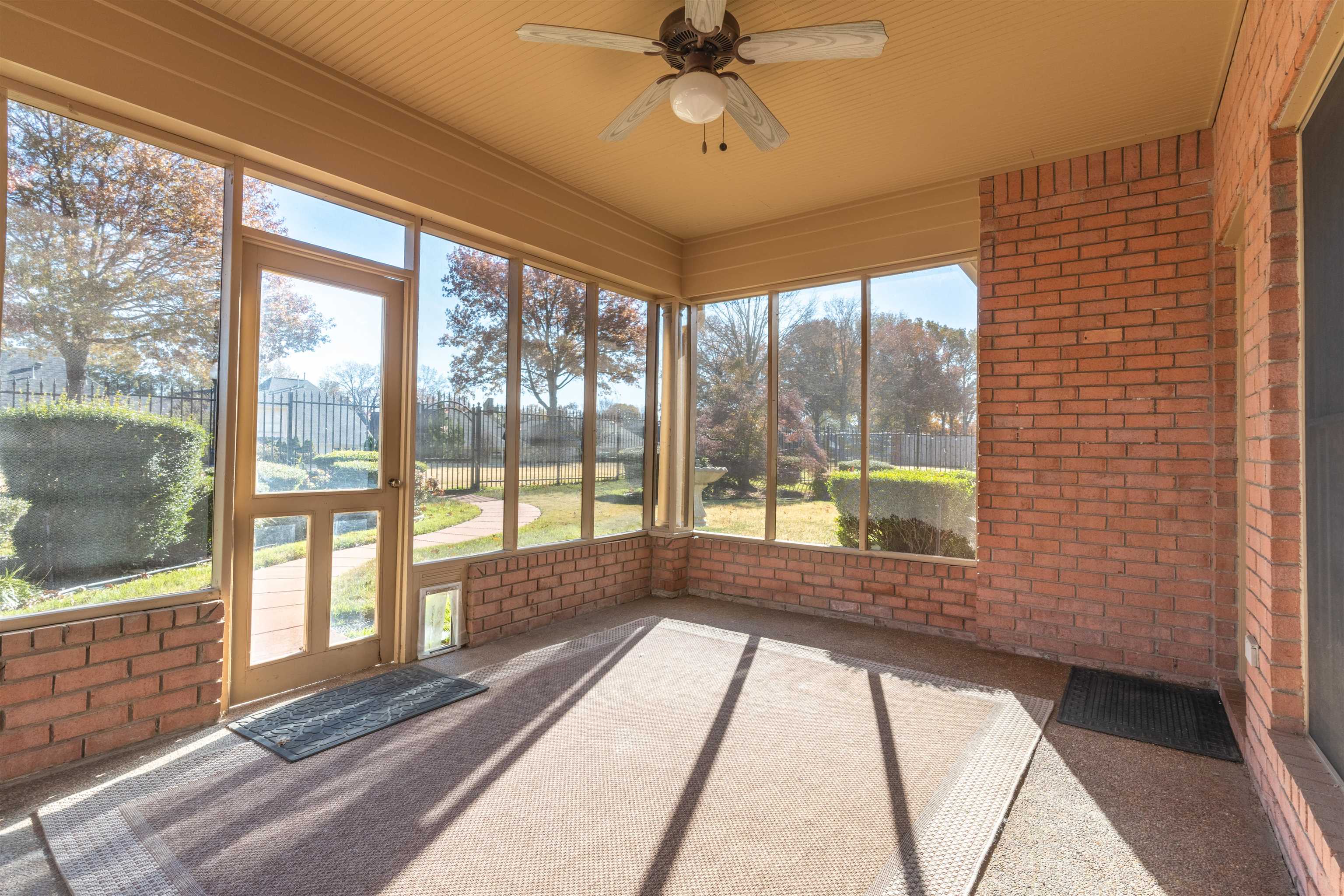 Unfurnished sunroom featuring ceiling fan