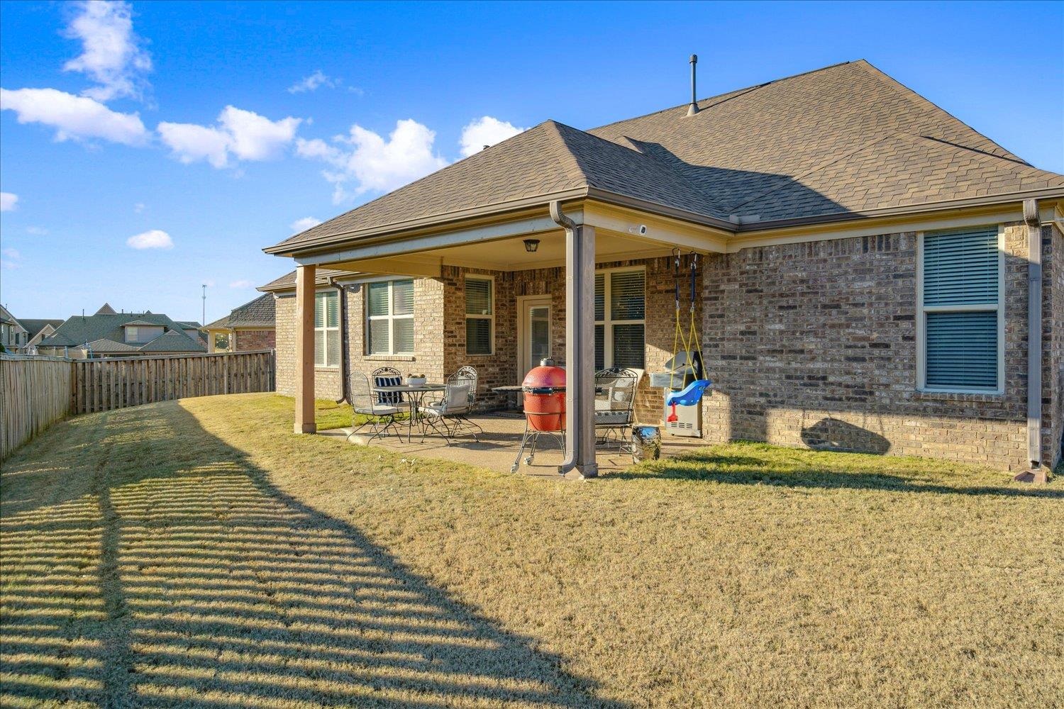 Rear view of house featuring a patio area and a lawn