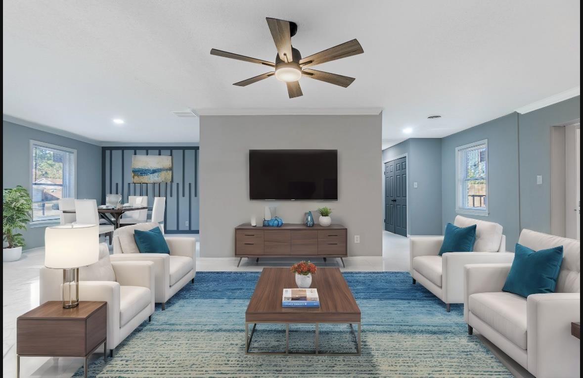 Living room with ceiling fan and ornamental molding