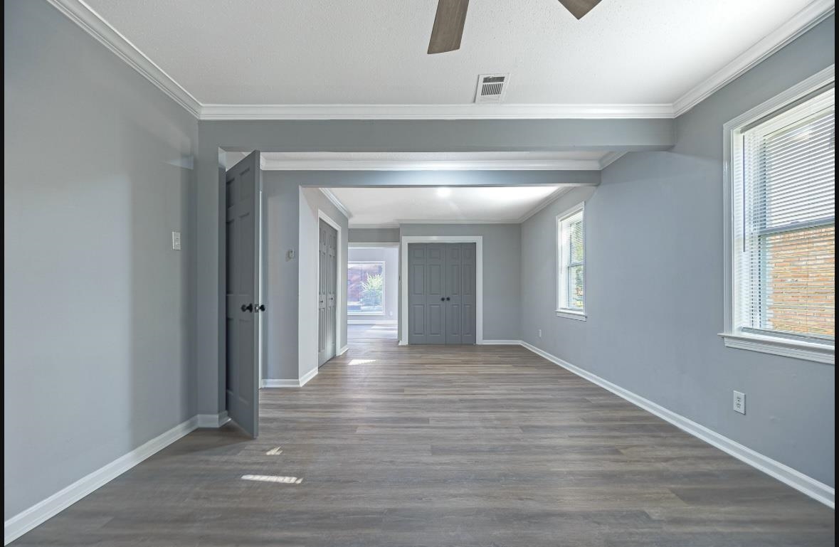 Hall featuring dark hardwood / wood-style flooring, a wealth of natural light, and crown molding