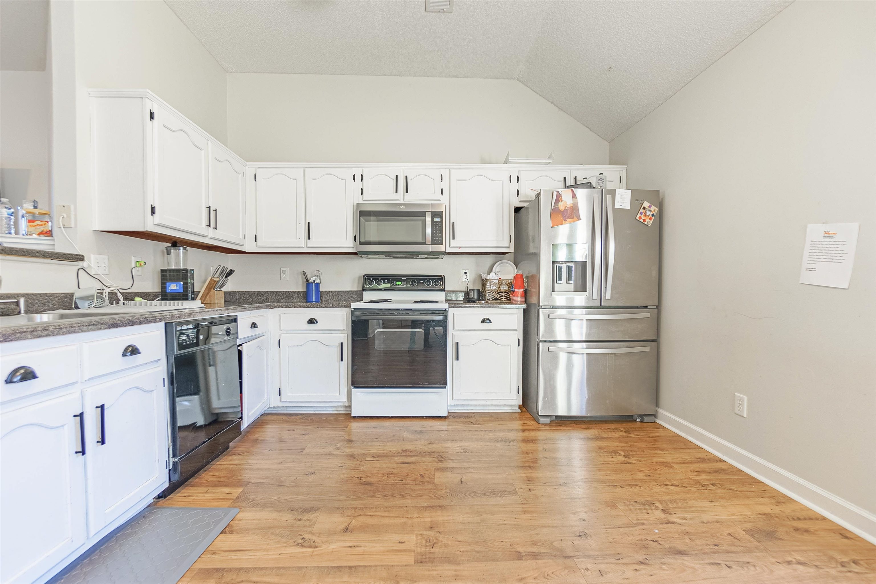 Kitchen featuring white cabinets, stainless steel appliances, and light hardwood / wood-style floors