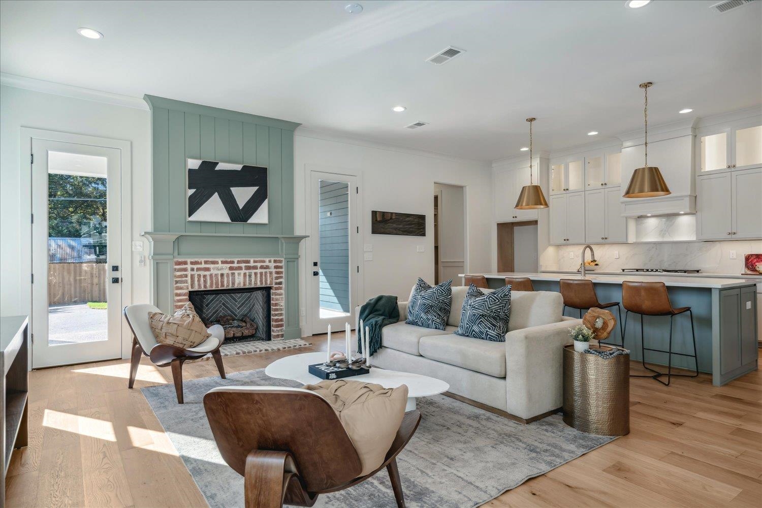 Living room featuring sink, crown molding, light hardwood / wood-style flooring, and a brick fireplace