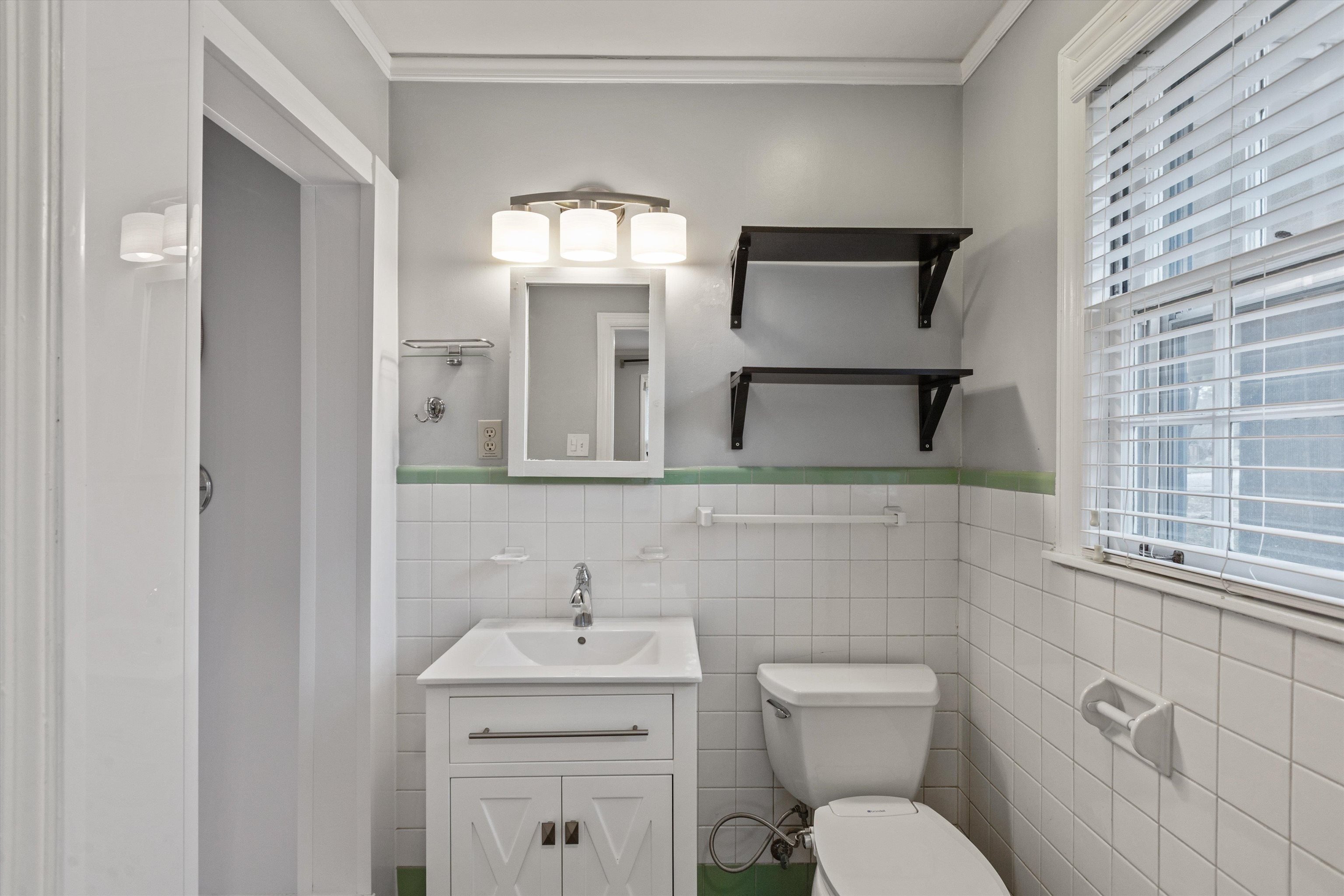 Bathroom featuring vanity, plenty of natural light, and tile walls