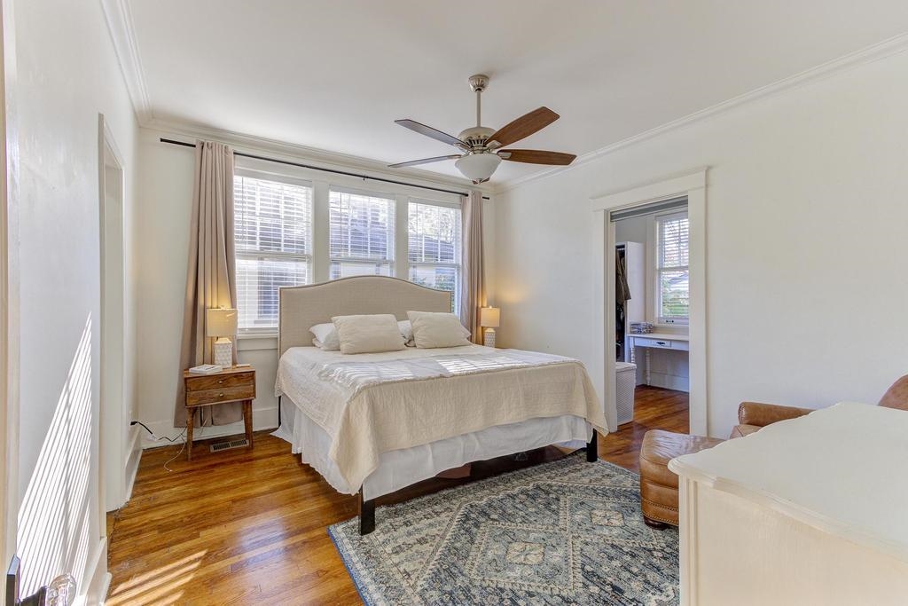 Bedroom with connected bathroom, light hardwood / wood floors, ceiling fan, and ornamental molding