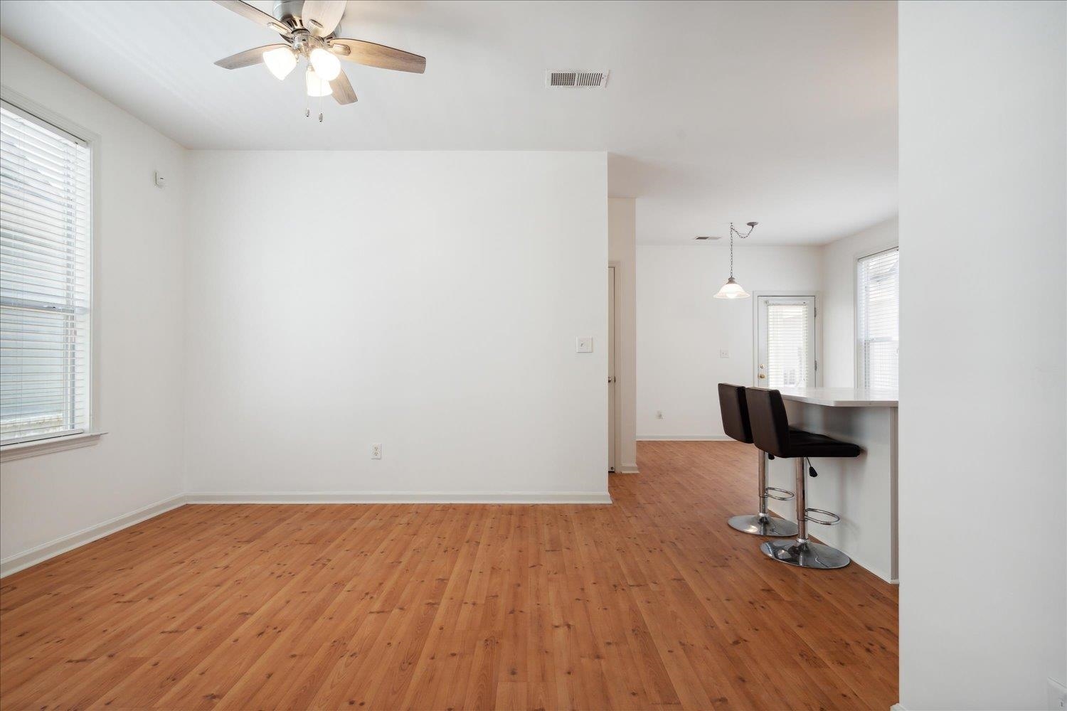 Spare room with a healthy amount of sunlight, hardwood / wood-style flooring, and ceiling fan