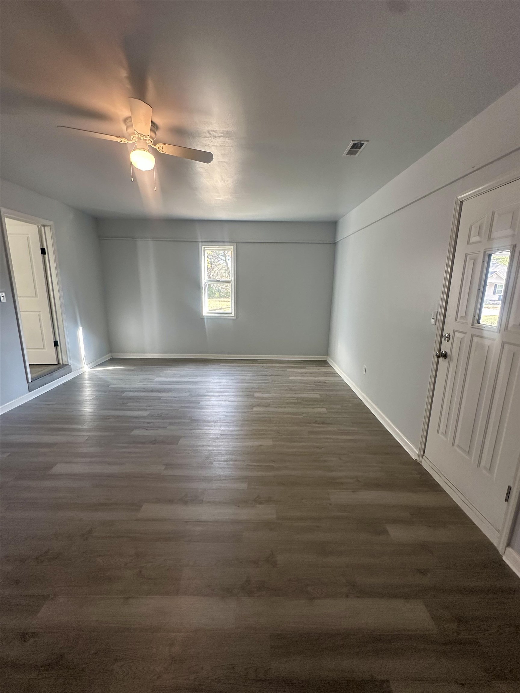 Unfurnished room featuring ceiling fan and dark wood-type flooring