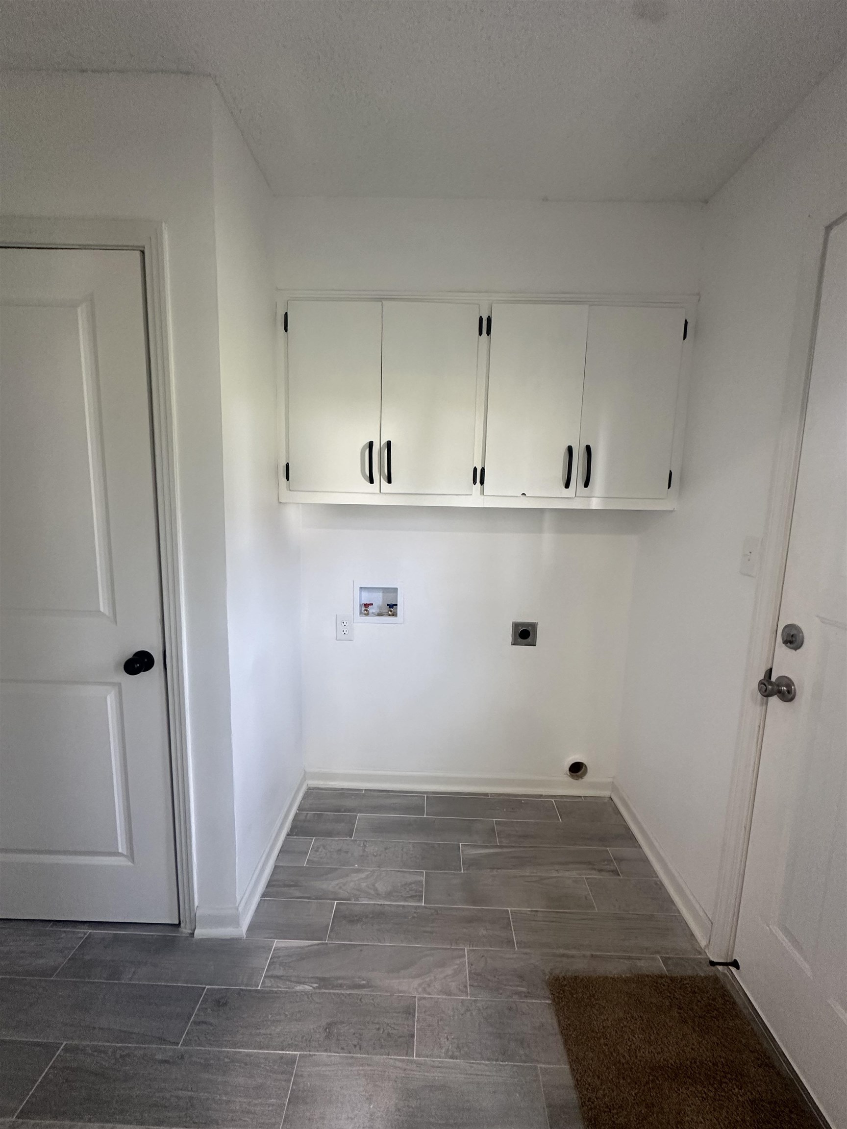 Laundry area with cabinets, washer hookup, a textured ceiling, and electric dryer hookup