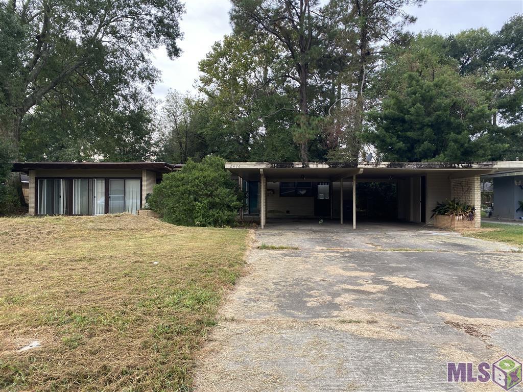 Located on a nice street, this is a four side brick exterior with built-in planters, double carport w/storage and wall of windows on a large lot with mature trees! Flat roof is tarped, interior reveals roof damage but this property has potential & could be a score! Two living areas, kitchen overlooks large eat-in area. Three large bedrooms, primary bedroom features a walk-in closet and private full bathroom.
