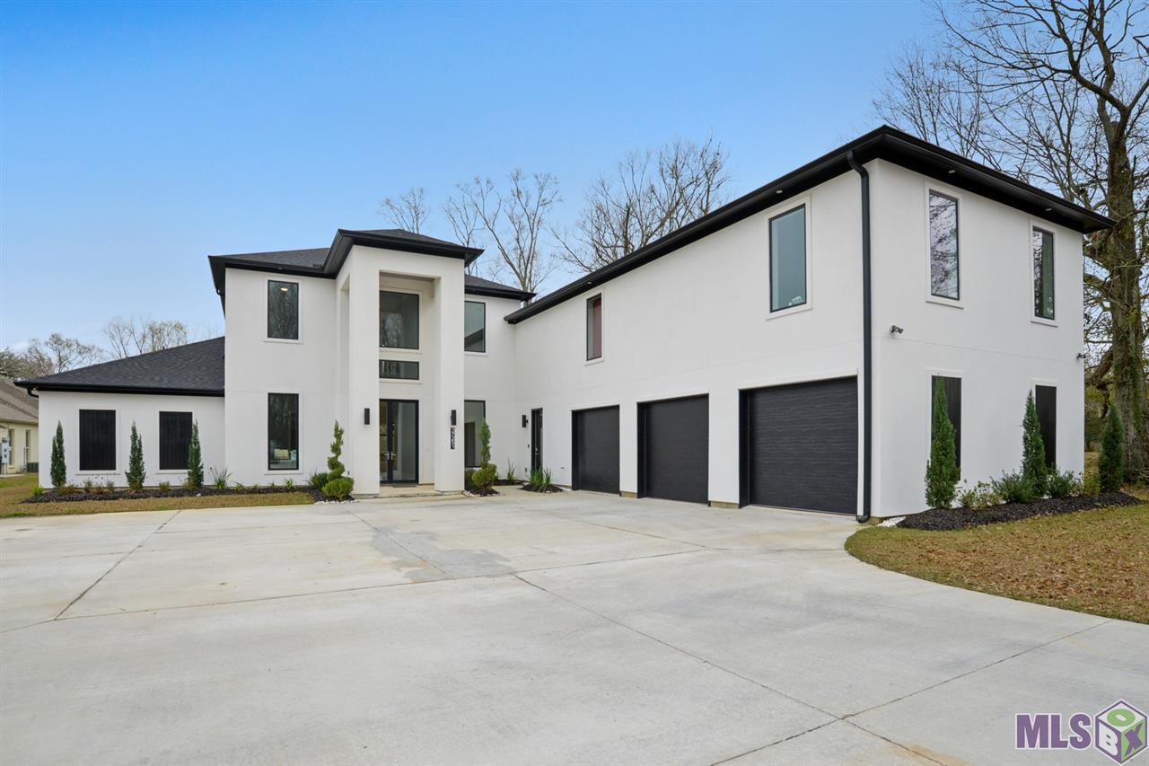 Present day modern design Home, Featuring 7 Bedrooms/4.5 Baths, rec room, craft room, large butlers pantry, additional 2 bedrooms currently being used as an office & playroom. Beyond a stylish entryway space the home flows into a luminous open-concept living, dining, and Kitchen area. The alluring kitchen is the heart of this home. It is complete with a large customized marble island, state of the art tile backsplash and  a suite of high end commercial stainless steel appliances. Downstairs Master sits just off the living area. 22 foot ceilings foyer, 12 ft and 9ft ceilings throughout, sleek finishes and lots of natural light throughout the entire home. Enter large extended porch with fireplace for entertaining right off the dining area through 9ft x 16ft sliding glass doors. Conveniently located near Airline Highway and I10.