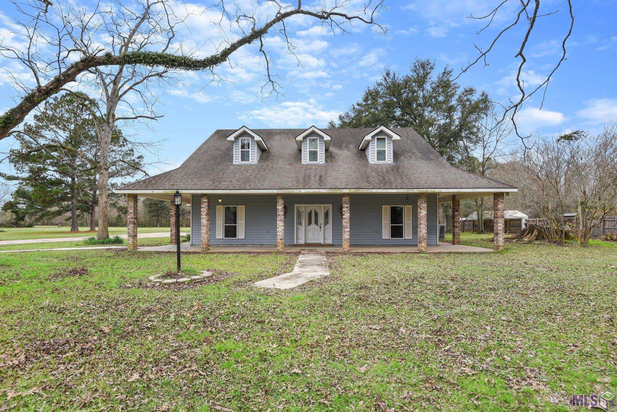 Recent Price Improvement! Spacious Acadian style home with a wraparound porch in the highly sought after City of Central, on just over an acre of land.  Home features soaring ceilings and Australian cypress flooring in the living room, lots of natural light, open floor plan, formal dining room, 3 large bedrooms, 2.5 baths. Built with foam and concrete walls, the average utility bill is around $120/month! The large, shaded yard has 5 mature pecan trees, a fig and persimmon tree, located in flood zone X! and DID NOT FLOOD in 2016! Call for your private showing today! Measurements not warranted by broker or agent.