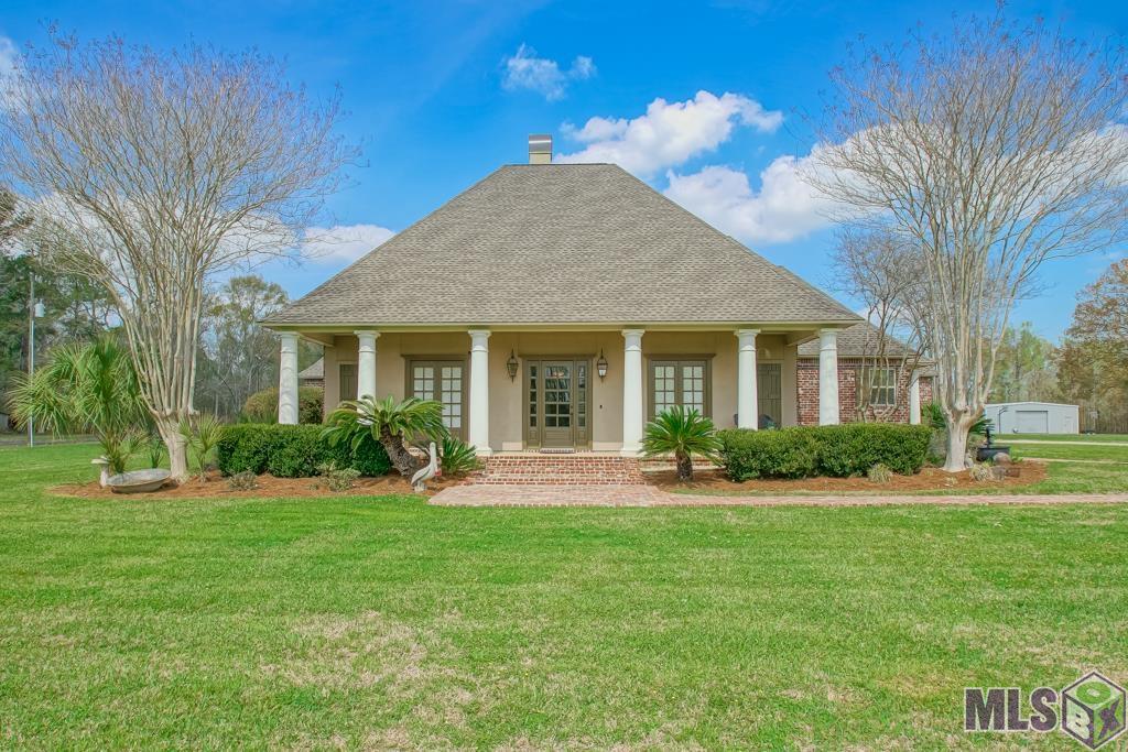 DID NOT FLOOD-ZONE X. FLOOD INS. NOT REQD. This Classic Acadian Estate on 4.89 acres is a slice of paradise in Central. Key 2021-2022 improvements: New 50-year GAF Shingle Roof. 2 new gas water heaters; 2 new outside air units; 1 new inside AC unit; New garbage disposal; New “Mo-dad” aerator; new pool filter grid system, liner and pump. Sentricon transferable termite baiting system and landscaped w/large barrier rocks at slab. 2 attic accesses w/ lots of decking & well insulated with extensive spray foam insulation.  You’ll notice the newly installed, antique brick walk-way leading to the six (6) stately columns adorning the massive gallery-style porch. Gas lanterns. French-doors welcome you into the foyer where Australian Cypress flooring adds to the allure of this home.  Two gas fireplaces feature upscale designer styles. Custom craftsmanship throughout; kitchen moldings and cabinetry is Australian Cypress. Brick pavers in kitchen, keeping and breakfast nook. 10 & 12 foot ceilings throughout, adorned with 3, 4 and 5 piece crown molding. All bedrooms are more than generously sized with a newly updated Jack & Jill bathroom.  All bedrooms have walk-in closets w/built-in dressers. Huge primary suite w/ large bathroom and a closet that won’t disappoint. The living room view to the covered patio & pool is enticing. The large patio and pool are surrounded by a commercial grade aluminum fence w/upgraded posts. Gentle pool fountains & subtle lighting will be tough to resist. Ask your Realtor for a complete list of interior amenities.  This property features an oversized 2-car carport w/ attached enclosed shop could possibly convert into livable space. A covered concrete pad is also included for additional storage. An amazing shop offers 2000 S/F and fully insulated w/radiant barrier foam board & plywood. It is a cooled space for a multitude of uses year-round. 7 miles to interstate. Virtual tour at: https://www.canva.com/design/DAFjAApeC