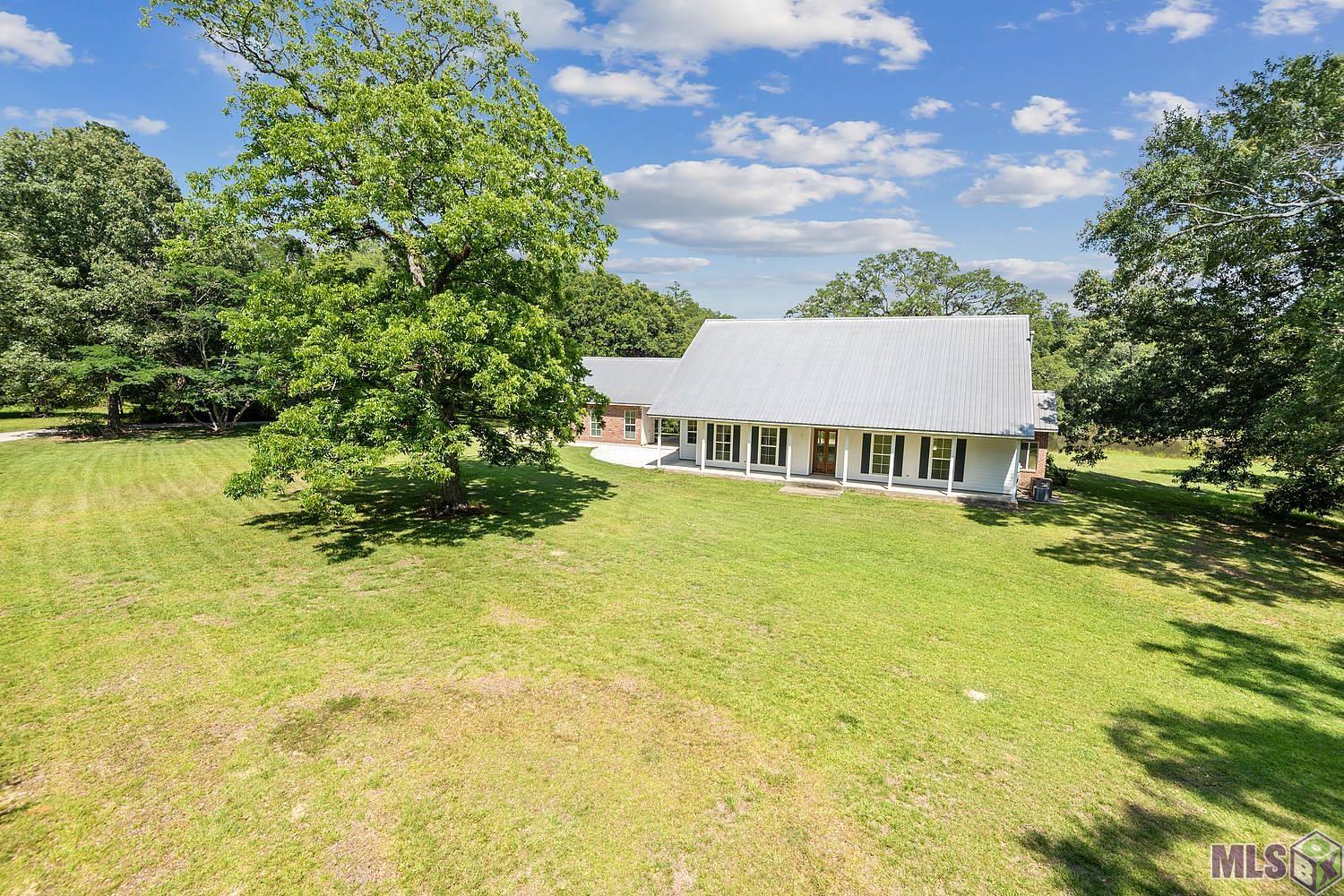 Incredible updated show place hidden among majestic live oak trees in Central with 10+ acres. Homesite is 10.49 acres with a huge stocked lake, open and wooded areas perfect for walking trails, ATVs or livestock.  Enjoy your large kitchen with Granite countertops and views of the lake and majestic live oak trees from every window. The large living room opens up to the full length back porch with the perfect views of the lake and wildlife.  This custom built home actually has all window views of the private lake across the entire back of the home. There are 3 bedrooms and 2 1/2 baths downstairs with an office.  Upstairs has one huge bedroom/game room and a bonus room. This is by far one of the most picturesque pieces of property in Central and only a few of it’s features.