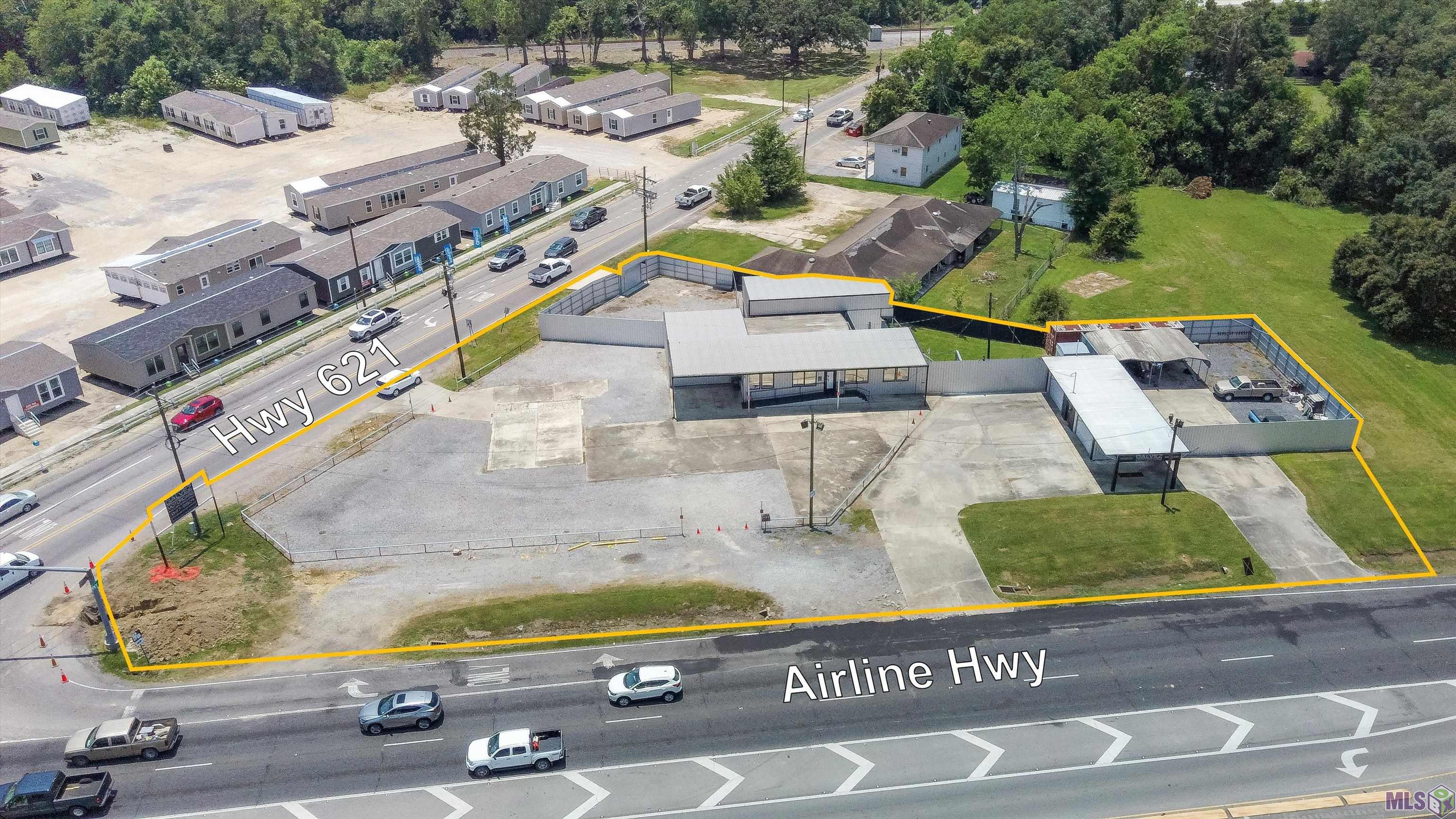 JUST REDUCED ON THIS INCREDIBLE LOCATION !!  Established automotive corner lot location in prime Gonzales area at Airline Hwy and Hwy 621 includes two lots including a previous car sales lot and automotive car wash. This property includes a double commercial lot of 1.33 acres. The 600 sq. ft. office with accessible ramp includes a private office, open sales staff area, bathroom, and lounge area. Several storage bins (374 sq. ft.) plus a 758 sq. ft. huge garage area provides ample space for inventory/parts. A large camper port extends 682 sq. ft., and the camper provides additional staff accommodations. Multiple car wash bays and carports are ideal for potential repair, service, or detailing services. The incredible road frontage to two major highways will prove priceless for the large gravel and concrete staging lot for traffic sales. This location is one of a kind with endless business potential !