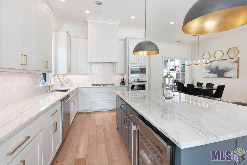 The kitchen has beautiful stainless appliances (love the wine fridge), quartzite countertops and amazing pendant lighting amongst other impressive details.