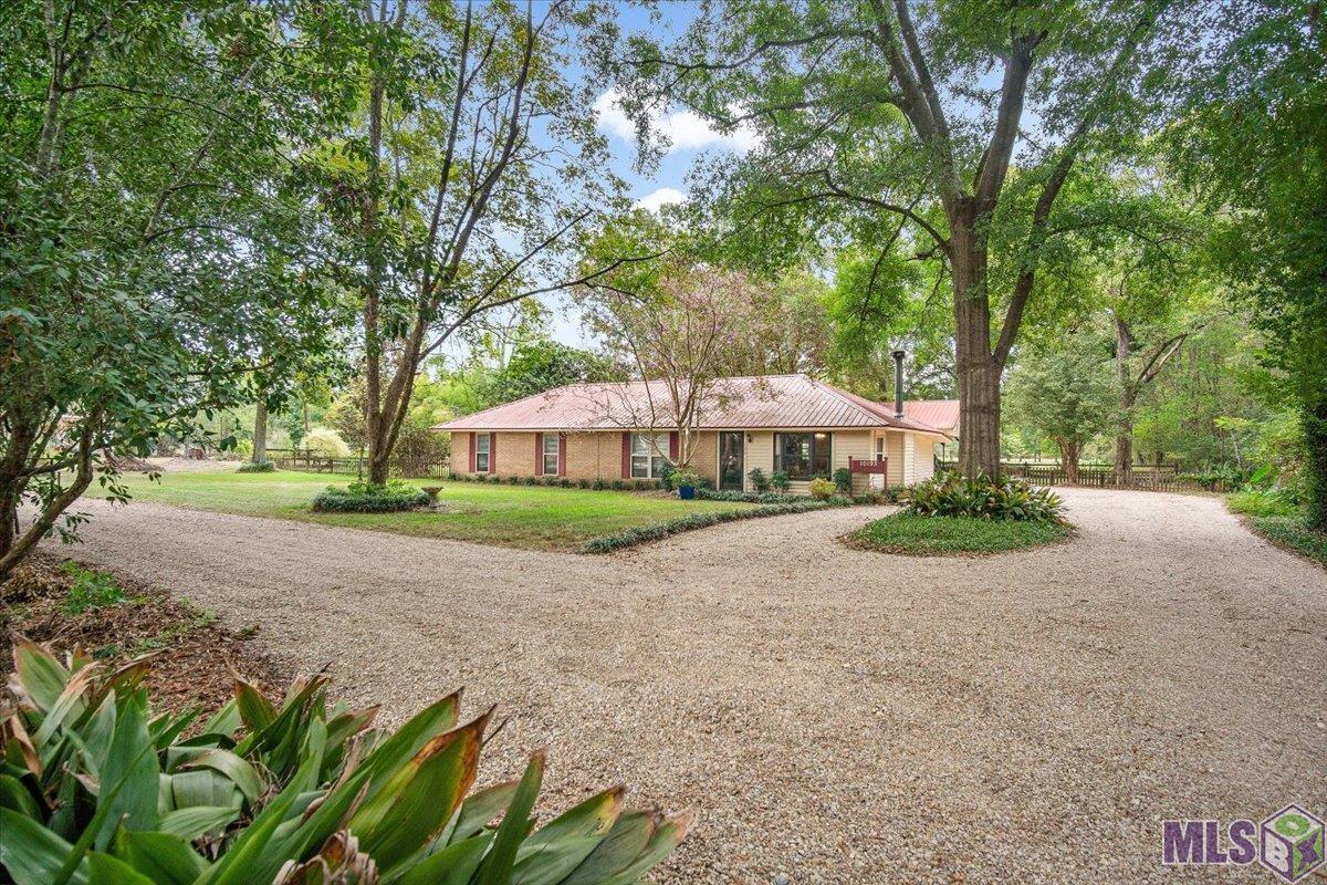 Discover your dream home on 9.81+/- acres of pristine land! This spacious 3-bedroom, 2-bathroom haven boasts a plethora of amenities. Outside, you'll find covered and open patios, mature shade trees, a 75x150 stocked pond, a 30x30 workshop equipped with water and electricity, featuring two 10x10 roll-up doors, a convenient chicken shed, a 15x20 detached boat port, and additional storage sheds. Inside, the welcoming living room showcases new Luxury Vinyl Tile Flooring, a ceiling fan, elegant crown molding, bay windows that provides the space with natural light, and a cozy wood-burning fireplace with a ceramic tile surround and mantle. An adjoining office/study adds flexibility to the layout. The kitchen boasts Luxury Vinyl Tile Flooring, solid countertops, a decorative tile backsplash, an eat-at breakfast bar, stainless steel appliances, and an electric range/oven. An adjoining formal dining area provides the perfect space for gatherings. All bedrooms feature the new Luxury Vinyl Tile Flooring, ensuring comfort throughout the home. Don't miss out on this exceptional property—schedule your private showing today and make your dream of acreage living a reality!