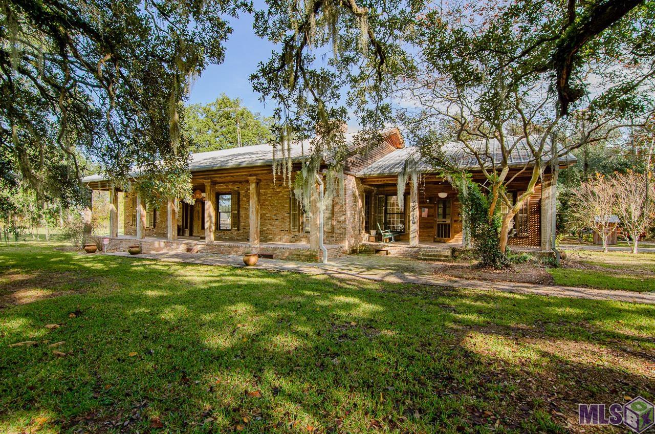 This custom built home is a Louisiana treasure. Large historic live oaks span the front lawn of this Acadian Home. Made completely by hand from Louisiana cypress, this home is truly a piece of art.   Upon entering the home you are greated by a large foyer which serves as the main corridor for all of the action inside of the home. The spacious living room is warm and cozy perfect for entertaining or simply spending time with loved ones.  The large main rooms, and multiple porches, make entertaining a breeze. The primary suite is complete with an en suite and two walk-in closets. The two additional bedrooms each have walk-in closets of their own as well as an adjoining bathroom.   A spacious bonus room upstairs, is complete with a second powder room. Make this room a home office, craft room, game room, or even a movie room!   Located to the rear of the property is a charming guest house. Complete with a full kitchen, bathroom, and three porches; this is the perfect spot for holiday guest.  On the property you will also find two gazebos (one of which has an outdoor powder room for outdoor entertaining) as well as two large sheds.   This property is a must see that you will not want to miss.