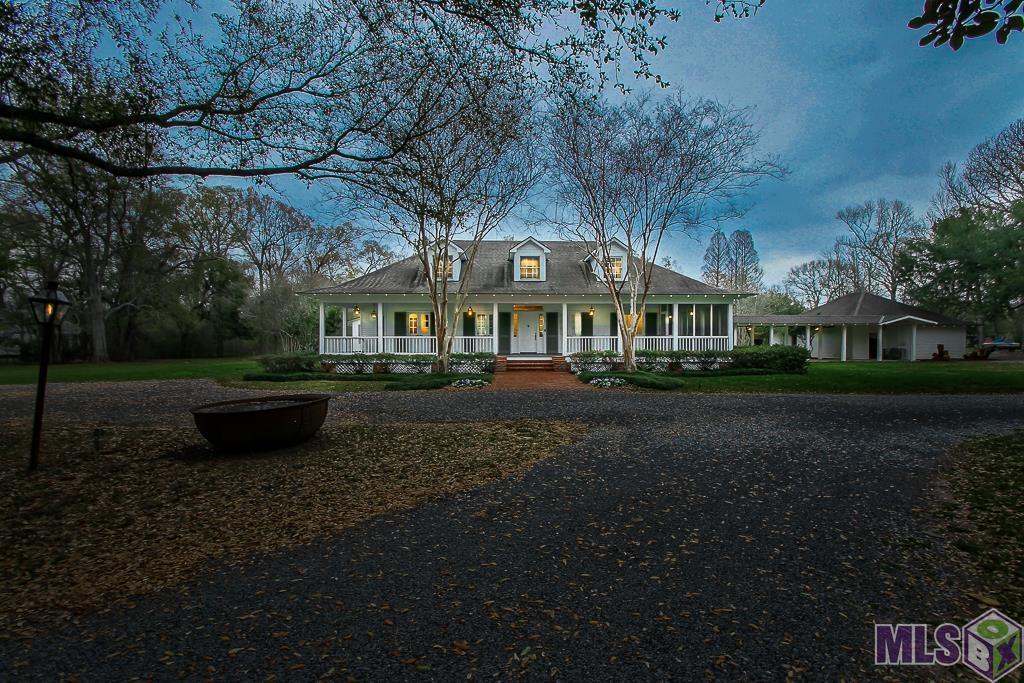 This rare jewel comes to market after being owned  by one family for 50 plus years is now ready for a  new beginning: 14+ acres surrounded with legacy live oaks, pond, pool, barn, storage and a second cottage. The large Acadian style home has 5 bedrooms (3 down) and 2 up for complete privacy and solitude on this beautiful high ridge. The wrap around porch and partial screened porch invite you for endless views of the sunset. Antique beams, vaulted ceiling, many updates in kitchen and baths through the years make this a desirable multi generational home.  The writer's cottage or the "get away" was built in 2000 and is tucked across the walkable bridge , with woods and trails. It has  2 bedrooms ,one bath and wooden flooring throughout with a full kitchen to allow you to think of times gone by.