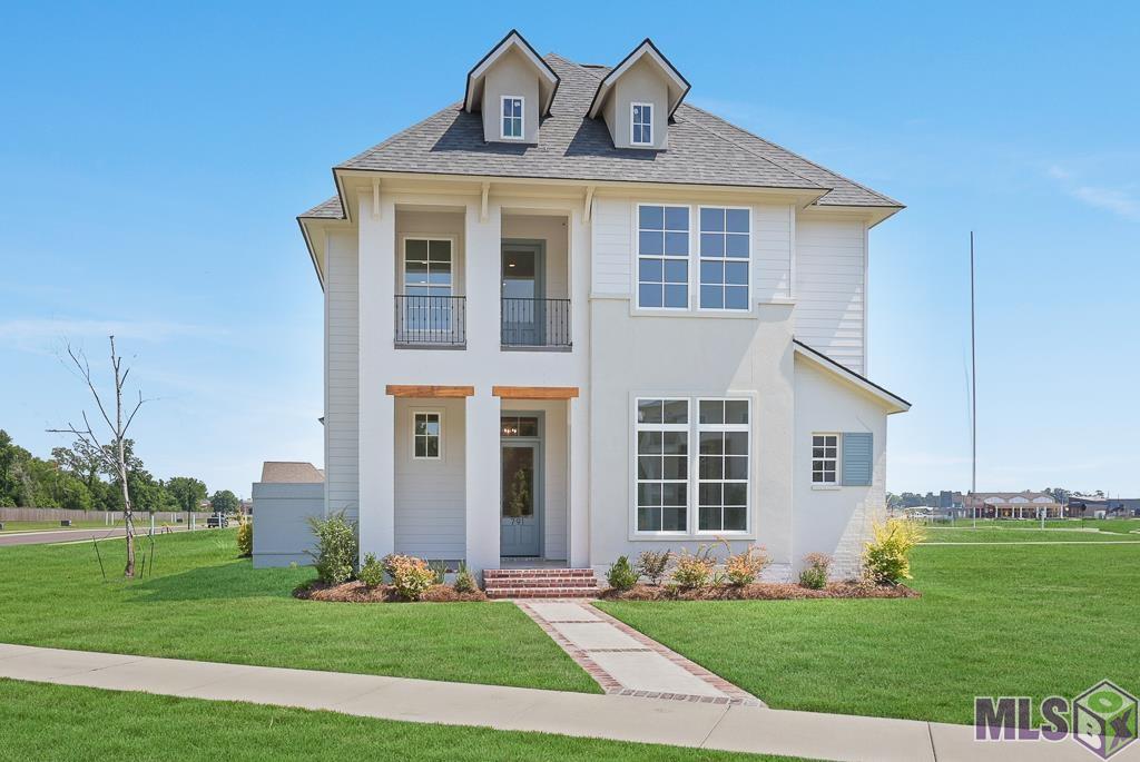 Please visit our on-site Agent at this home from 12-4p Tues -Sun. Custom built by Bond Construction and complete. At entry, first notice the striking 12 ft ceilings creating a grand entrance along with a bank of windows overlooking the private courtyard. The kitchen is designed with entertaining in mind and includes an island accommodating four barstools, quartzite countertops, Bertazzoni Italian engineered appliances, along with a bar with built-in wine cooler and custom cabinets. Toward the back of the home, you'll walk through grand 8 foot doors to find an owner’s suite opening to a luxurious bathroom designed for ultimate relaxation. Here you'll appreciate a freestanding bathtub, 4x4.5 ft glass-enclosed shower with accent tile extending to the ceiling, and extensive vanity and cabinet space for all your storage needs. The spacious closet includes a built-in double dresser, making dressing for the day or evening a breeze. Another bedroom with en suite bath is located downstairs away from the owner's suite, offering maximum privacy for guests. An office and powder room are also downstairs just down the hall. Indoor and outdoor living seamlessly blend as you enter the courtyard through french glass doors and find tile under foot, a full outdoor kitchen, under a cathedral ceiling surrounded by a brick privacy wall, creating a space ideal for creating memories with friends and family. A small green space for furbabies or a herb garden is accessible inside this courtyard. Laundry room finished with cabinetry, quartz counter, and sink along with a drop zone at the garage entry make everyday living easy. Two sizable secondary bedrooms with a shared bath and versatile loft/flex space opening to a functioning balcony space are located upstairs. Planned community pool and pavilion coming soon. Residents can enjoy a culinary experience at Alexander's Grocery, arts and entertainment at the PACE Center, spa conveniences at Bronier and fitness classes at HotWorx.