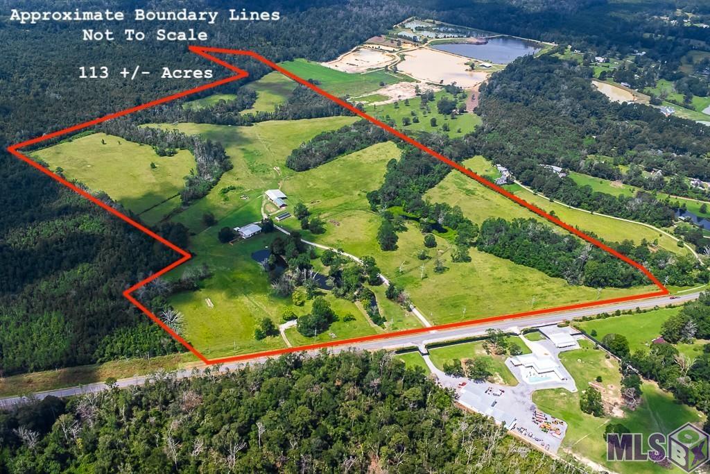 Discover the ultimate blend of country living and modern comfort on this expansive 113.09-acre property offering the perfect retreat for those seeking a tranquil, rural lifestyle with ample space and endless possibilities. There is a very nice 2,250 sq ft metal structure home that serves perfectly as a small home, would be a great weekend get-a-way, or a guest house upon construction of a main home. On the first floor, you'll find a spacious bedroom, a full bathroom, and an inviting living area. The kitchen features stainless steel appliances, granite countertops, bar seating, and an open layout to the living and dining areas, creating a perfect space for entertaining. Ascend to the second floor, and you'll discover a loft-style bedroom providing a private and cozy retreat and an exterior balcony overlooking the property. Outside, the home extends its charm with an additional 2,250 sq ft of covered carport and patio area. Relax and take in the breathtaking views of the property, which includes three serene ponds and picturesque pasture land with scattered wooded areas. The outdoor space also features a large storage room and a fully equipped outdoor kitchen, ideal for gatherings with family and friends. The property is fully fenced and cross-fenced, making it ideal for cattle and horses. A large barn is thoughtfully set up for working cattle, accommodating livestock, and storing equipment, ensuring all your agricultural needs are met. Recreational opportunities abound on this sprawling estate. Whether you enjoy hunting, fishing, or simply exploring the great outdoors, this property offers it all. The expansive land, combined with the natural beauty of the ponds and wooded areas, provides the perfect backdrop for a variety of outdoor activities and ample wildlife. Don't miss this rare opportunity to own a piece of paradise South of Denham Springs. Whether you're looking to run a working farm, or develop your family estate, this is the perfect place to call home.