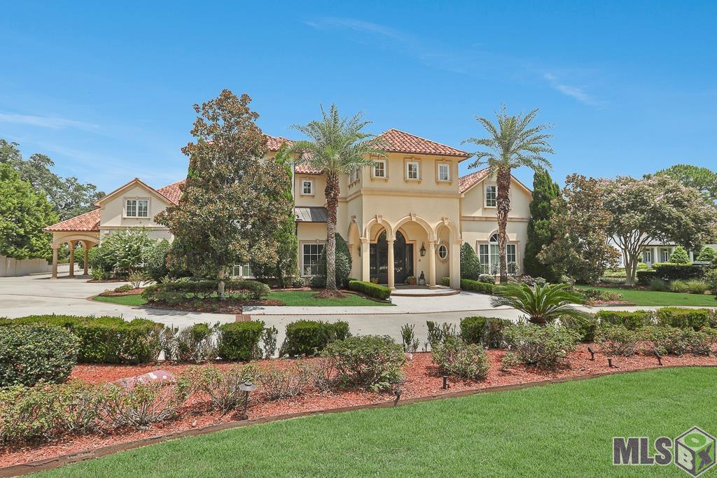 Welcome to the stunning property at 19411 North Muirfield Drive in Baton Rouge, Louisiana, located in the prestigious Country Club of Louisiana. This luxurious estate offers a total of 7 bedrooms, including 8 full baths and 4 half baths, ensuring ample space for comfort and privacy. The open floor plan creates a light and spacious atmosphere, complemented by large windows and skylights throughout allowing family and friends to enjoy multiple gathering spaces.  Beautifully perched on a lake lot measuring over an acre, this home provides a serene waterfront view and features a magnificent saltwater pool, perfect for outdoor relaxation and entertainment. Every bedroom in this home is an en-suite, providing ultimate convenience and luxury for all occupants. The kitchen is a chef's dream, equipped with three cm slab granite countertops, custom cabinetry, and an additional separate chef's kitchen for added versatility. The master suite boasts a separate wing, his and hers closets, large walk-in stone shower and soaking tub, with a large attached office, ensuring a secluded and private retreat. The home features travertine and wood flooring, along with two cozy fireplaces for added ambiance. Entertainment options abound in this home, with a large media room upstairs featuring a screen and wet bar, as well as an additional game room for gatherings. Multiple balconies offer tranquil spots to sit and relax while enjoying the beautiful surroundings. Constructed with solid concrete between floors and on the exterior, this home is built to last. A Geothermal HVAC system and solar panels keep your energy bills super low!  Other features include a porte cochere, irrigation system, greenhouse/sunroom, three-plus car garage, and a custom-made imported front door. Don't miss the opportunity to own this exceptional property that seamlessly combines luxury, functionality, and elegance. Schedule a viewing today and see all of this for yourself.  It's a real beauty!