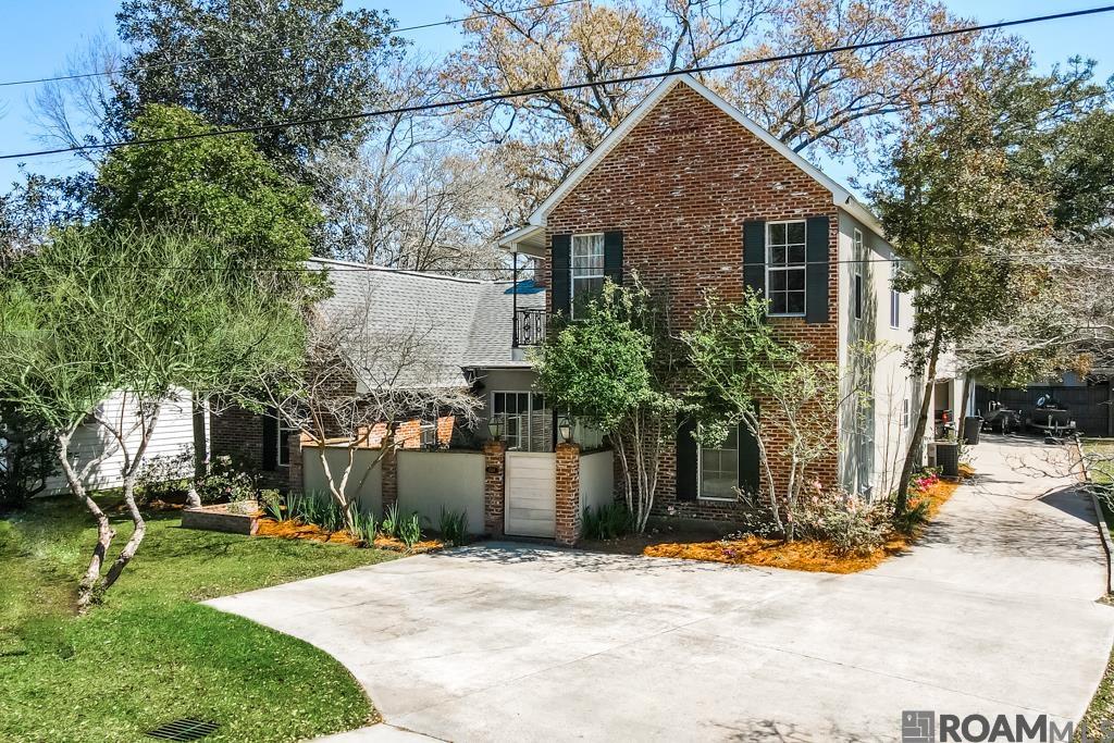 Stunning New Orleans style architecture! Southdowns Gem boasting over 4000 square feet living space. Tranquil Elegance as you enter the brick courtyard adorned with a century-old ironwork gate. Beautiful interior features with reclaimed old pine floors and 9-foot ceilings..  SPACIOUS OPEN FLOOR PLAN- PERFECT FOR GATHERINGS Fireplace with cypress cabinets. Expansive formal dining room, illuminated by natural light pouring in through large windows.  Gourmet kitchen boasts an island, granite countertops, and custom cypress millwork throughout. Master suite retreat, built-in cabinets and a lavish bathroom, slate shower, separate tub, and his/her walk-in closets.  Additional downstairs versatile room, ideal home office or extra bedroom.   Upstairs, two bedrooms and a children's lounge, each with private balconies, Outside, an oversized workshop offers endless possibilities, whether it be a fitness studio, art space, or man cave.Landscaped grounds and central vacuum system add to the convenience and charm of this exceptional property. Conveniently located just minutes from I-10, schools, dining, and shopping, this meticulously maintained home awaits its next discerning owner.