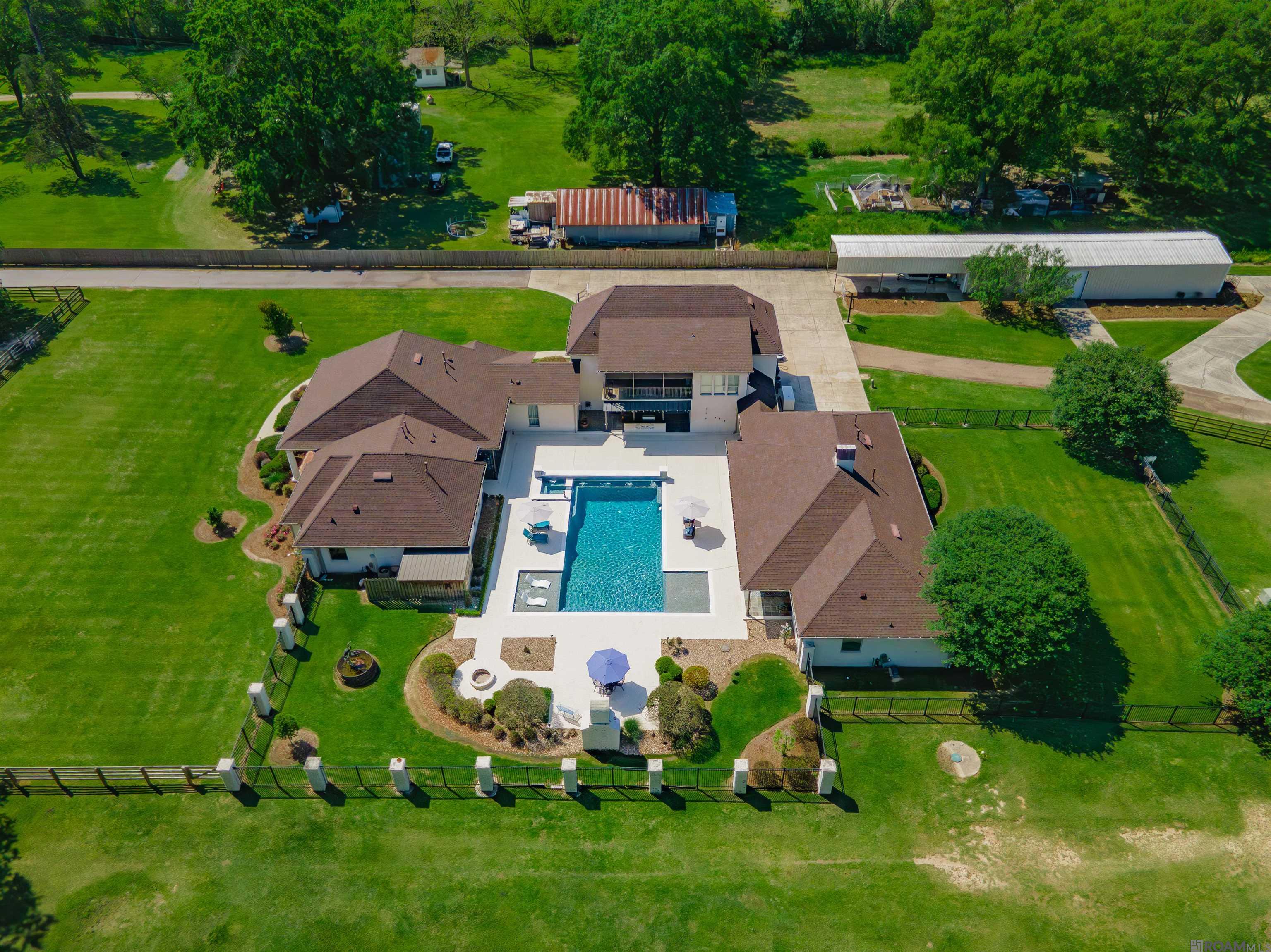Gentleman's Country Estate and Horse Farm.  Five minutes from Central Private.  If you're looking for space, you've found it!  This estate boasts 17 cleared acres, three ponds, 4400+/-sq. ft. main house plus an approx. 2200 +/- sq. ft. two bedrooms guest house with the same finishes as the main house.  Brand new roof.  The main house has five bedrooms, four baths, a home theater, a 32' x 24' bonus room with kitchenette, state of the art sound system inside and out.  Both homes overlook the gorgeous pool, outdoor kitchen and fireplace.  The property also features a 24' x 54' workshop, covered RV parking, four car garage and a full house generator.  For Horse lovers, there are seven horse stalls, with a washing bay, infirmary/quarantine area, a fly/bug misting system and a riding arena.  The attention to detail is unbelievable.  Primary bath has heated floors, keyless entry on most exterior doors, epoxy garage floors, security cameras and much more!  This rare gem has too many amenities to list.  You will have to see it to believe it.  Owners have lovingly maintained this property and it shows.  All furnishings and  farm equipment are for sale. Call today for your private showing.