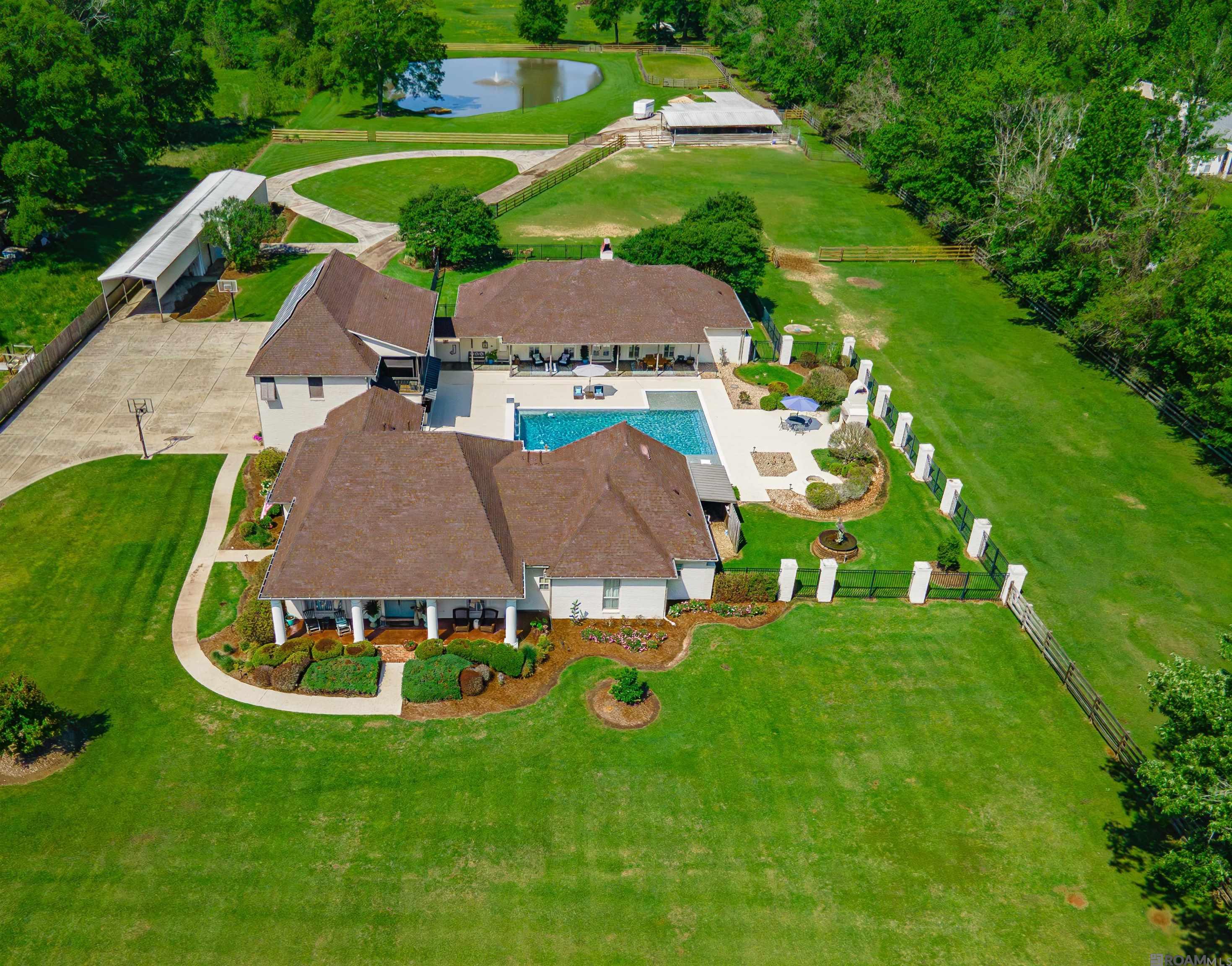 Gentleman's Country Estate and Horse Farm.  Five minutes from Central Private.  If you're looking for space, you've found it!  This estate boasts 17 cleared acres, three ponds, 4400+/-sq. ft. main house plus an approx. 2200 +/- sq. ft. two bedrooms guest house with the same finishes as the main house.  Brand new roof.  The main house has five bedrooms, four baths, a home theater, a 32' x 24' bonus room with kitchenette, state of the art sound system inside and out.  Both homes overlook the gorgeous pool, outdoor kitchen and fireplace.  The property also features a 24' x 54' workshop, covered RV parking, four car garage and a full house generator.  For Horse lovers, there are seven horse stalls, with a washing bay, infirmary/quarantine area, a fly/bug misting system and a riding arena.  The attention to detail is unbelievable.  Primary bath has heated floors, keyless entry on most exterior doors, epoxy garage floors, security cameras and much more!  This rare gem has too many amenities to list.  You will have to see it to believe it.  Owners have lovingly maintained this property and it shows.  All furnishings and  farm equipment are for sale. Call today for your private showing.