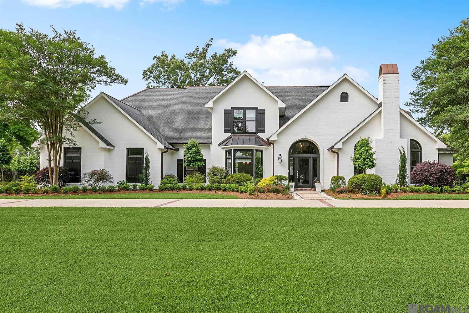Welcome to 18629 St Andrews Court, a beautifully updated 5-bedroom, 4.2-bath estate on a 1.02-acre lot in the gated St Andrews neighborhood off Perkins Road in Prairieville. With 4,800 square feet of living space, this stunning home offers privacy, elegance & comfort—just minutes from Baton Rouge & I-10. Surrounded by mature trees & timeless architecture, the home welcomes you with soaring ceilings, natural light & dramatic two-story windows overlooking the private backyard & resort-style pool-ideal for fun-filled living & entertaining. The expansive living room features a custom fireplace, built-in bookcases, stylish updates throughout, including new windows, LED recessed lighting & modern light fixtures & fans. Just off the foyer, a cozy home office with fireplace offers the perfect retreat or workspace. The large, eat-in kitchen is a chef’s dream with new marble countertops, a center island, breakfast bar, new Viking appliances (gas cooktop, wall oven, microwave & refrigerator) & newly added walk-in pantry. A formal dining room completes the entertaining space with style. The main-level primary suite is a private oasis with fully renovated en suite bath featuring freestanding soaking tub, frameless glass shower, double vanities, a beautiful chandelier & three walk-in closets. All bathrooms have been upgraded with new countertops, sinks, faucets & toilets. Upstairs, 2 staircases lead to 4 spacious bedrooms & a large rec/game room, perfect for media, hobbies or play. The home also features new hardwood & tile, new carpet upstairs, & fresh paint inside & out, making it completely turnkey. Outdoor living is a dream with a screened porch off the kitchen, ideal for morning coffee or evening wine. Additional features include a large utility room w/half bath & built-in desk, oversized double garage with boat port & circular driveway. The fully fenced backyard adds privacy & peace of mind. Whether you’re hosting, relaxing, or working from home this home has it all!