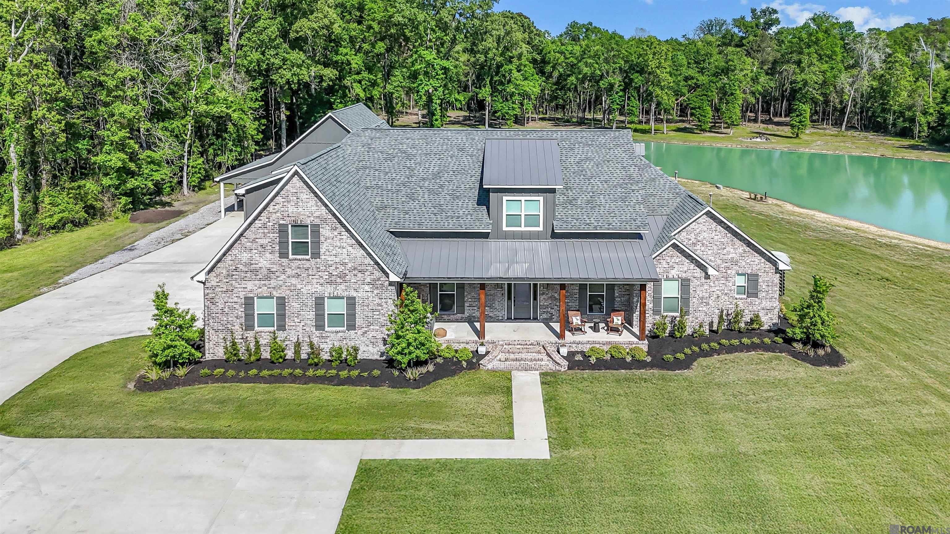 Welcome to the extraordinary 16024 La Hwy 431. This 6-bedroom, 4.5-bath luxury estate nestled on a breathtaking 19.28-acre property, complete with a fully stocked 1.5-acre pond and every amenity you could dream of. Spanning 3,862 square feet of expertly designed living space, this home is a rare blend of modern sophistication and peaceful country living. Step inside to find soaring ceilings, reclaimed hardwood flooring, and a showstopping great room featuring a floor-to-ceiling brick fireplace, built-in shelving, and tall ceilings with exposed beams. The open-concept design flows into a warm and welcoming dining area with panoramic views of your private oasis. The heart of the home is the chef’s kitchen, outfitted with top-of-the-line Thermador appliances, an oversized walk-in pantry, custom cabinetry, and generous prep space—designed for serious entertaining. A dedicated media room and home office provide both comfort and flexibility for work and play. Retreat to the luxurious primary suite with a spa-inspired master bath and a huge walk-in closet that’s a dream come true. Each additional bedroom is spacious and thoughtfully laid out to accommodate family and guests in comfort. Outdoors, enjoy the covered patio with a full Blaze-equipped outdoor kitchen, perfect for relaxing evenings by the pond or hosting gatherings in style. A two-car garage, extended driveway, and additional 40x40 fully insulated shop with bathroom provides ample space to store your boat and additional vehicles. Efficiency meets luxury with 2 tankless water heaters and 3 high-efficiency AC units, ensuring year-round comfort and energy savings. This one-of-a-kind estate is more than just a home—it’s a lifestyle. With unmatched privacy, high-end features throughout, and stunning natural beauty, this property offers the best of both worlds: upscale country living with modern elegance. This home is pre-wired and ready for a heated/chilled pool. This home does not require flood insurance.