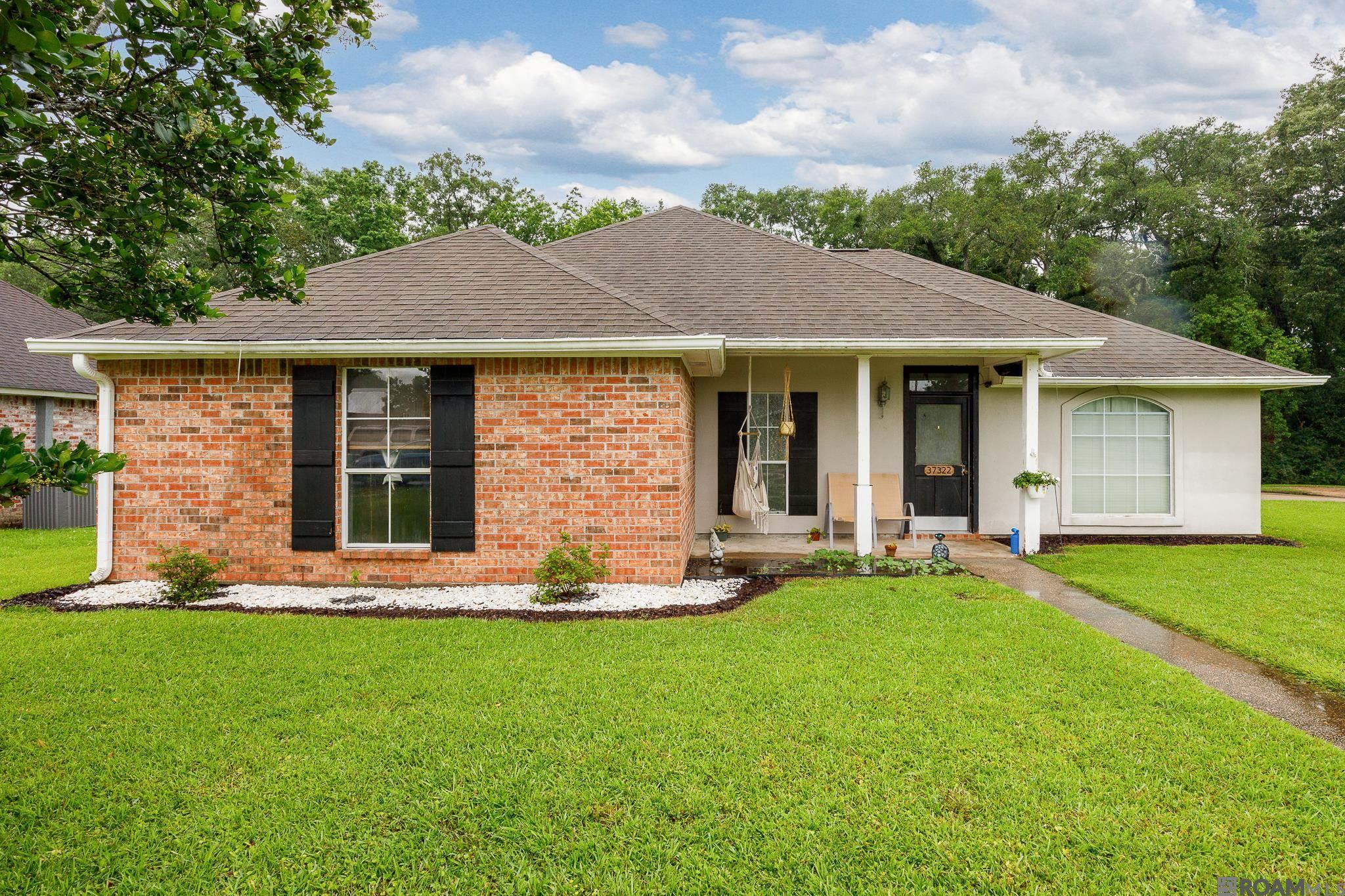 Tucked away on a peaceful dead-end lot and backing up to a tranquil wooded area, this beautifully maintained 3-bed, 2-bath gem offers the perfect blend of privacy, space, and modern comfort. With 1,696 sq ft of thoughtfully designed living space and an open floor plan that invites natural light throughout, you’ll feel right at home the moment you walk in. Gather around the cozy wood-burning fireplace, or cook up a feast in the stunning kitchen featuring stainless steel appliances, a center island with built-in oven, ample cabinetry, and generous pantry space. Each bedroom boasts walk-in closets, while the spacious primary suite steals the show with two walk-ins, a luxurious en-suite bath complete with double vanities, jetted tub, and a separate shower for a spa-like retreat. NO Carpet! A converted attached storage shed offers bonus space for a home office, guest room, or extra storage, all kept comfortable with a window unit. Enjoy the outdoors with a covered and extended open patio, privacy fence, and generously sized backyard—perfect for entertaining! Conveniently located in a quiet neighborhood near I-10, Airline Highway, Walmart, Rouses, restaurants, and so much more! No Flood Insurance Required! 100% Financing Available! Opportunities like this don’t come often – call today for your private showing!